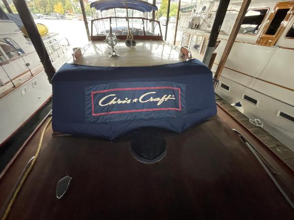 1951 Chris-Craft Catalina boat with cover, docked in a marina.