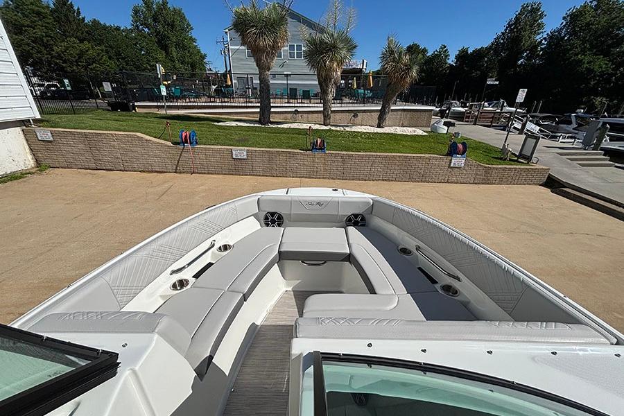 2027 Sea Ray SDX 230 Outboard boat with spacious seating, docked near palm trees.