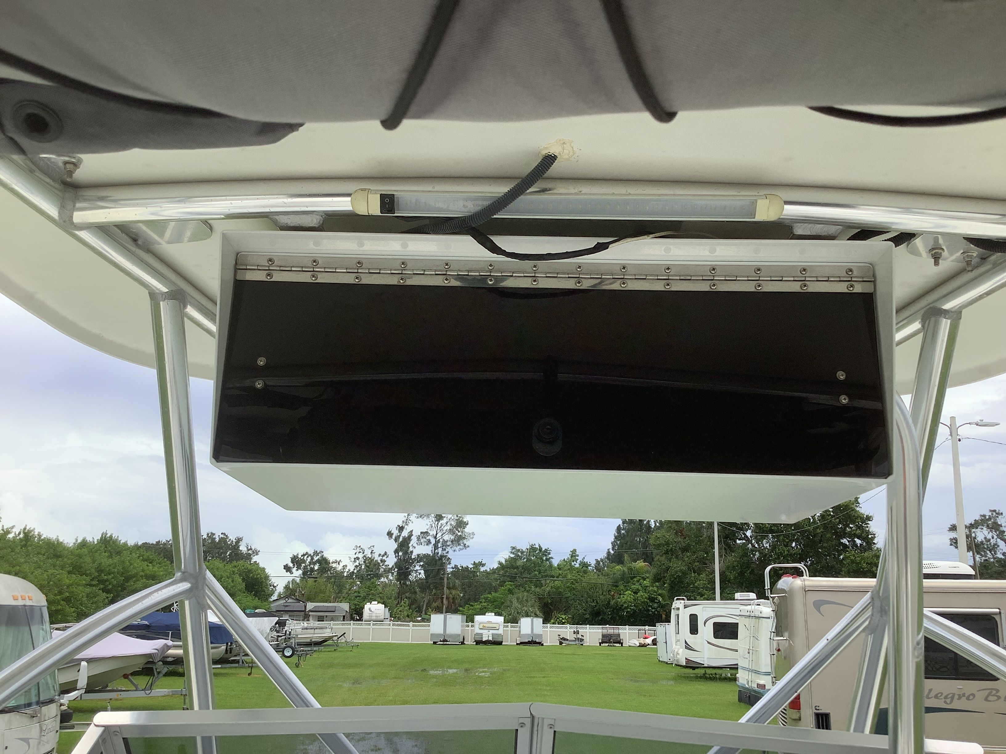 View from a boat roof with metal frame and black compartment. RVs in the background.