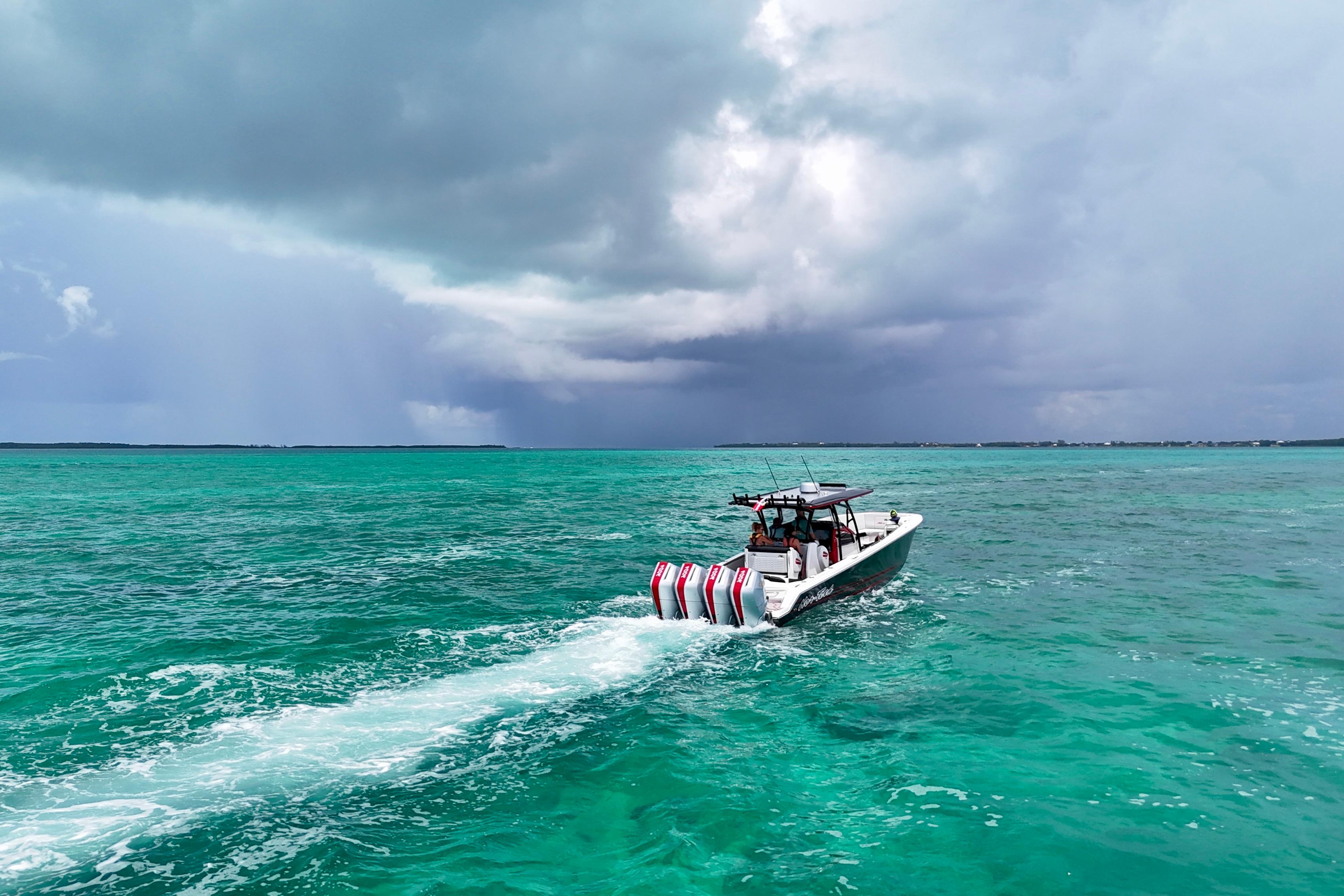 2026 Nor-Tech 390 Sport Center Console cruising on turquoise ocean under cloudy sky.