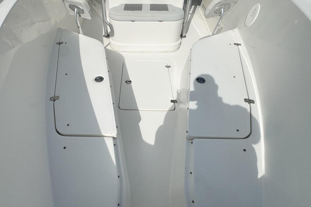 Interior view of a 2018 Mako 284 Center Console boat, showcasing seating and storage compartments.