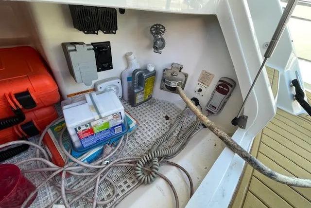 Storage compartment of a 2016 Sea Ray Sundancer 510 with cables and equipment.