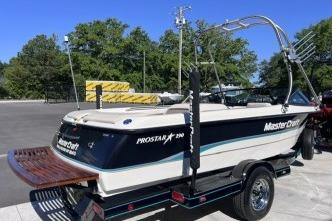 1996 MasterCraft ProStar 190 boat on trailer, parked outdoors with trees in background.