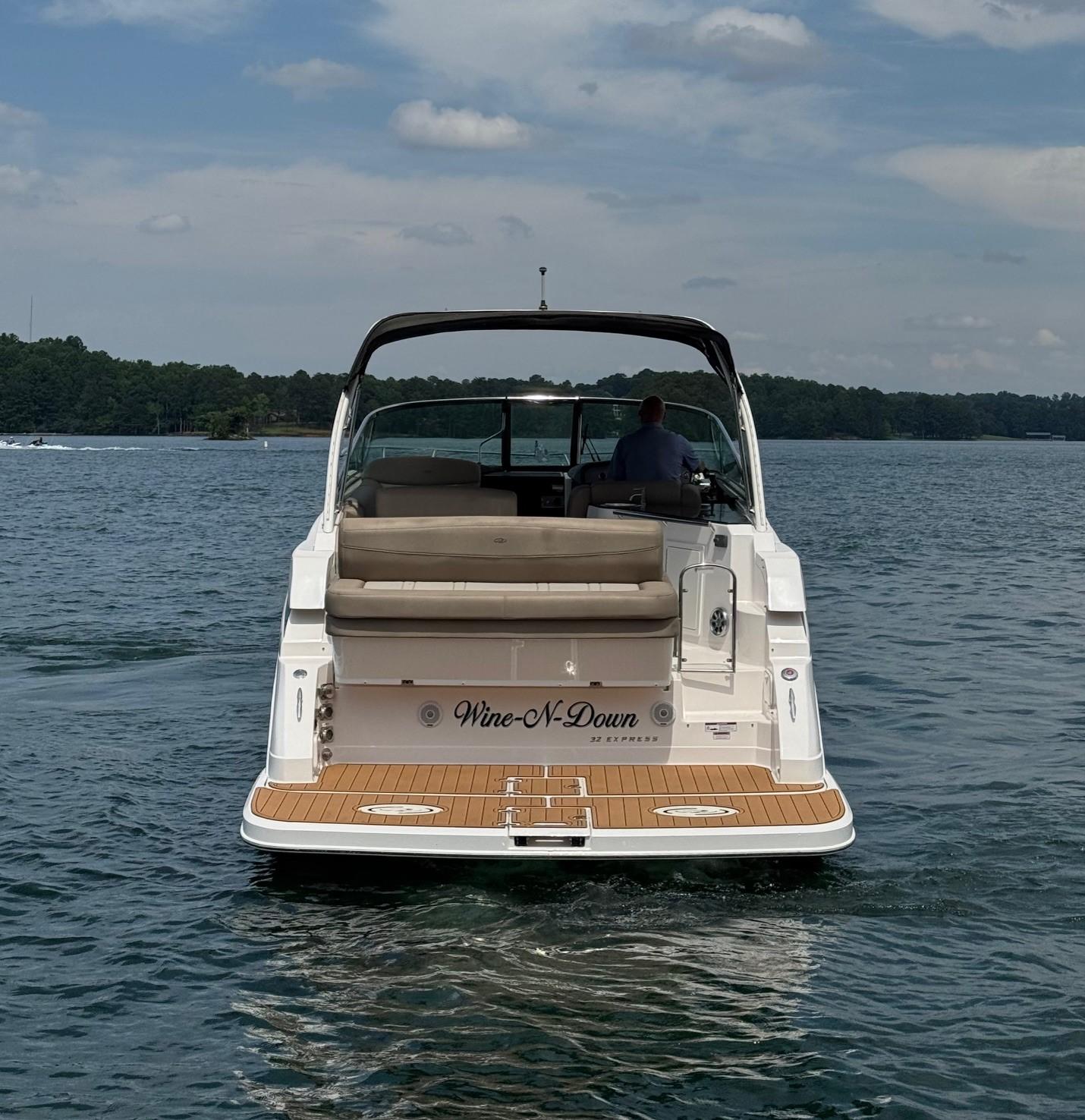 2014 Regal 32 Express boat on water, rear view, with "Wine-N-Down" name.