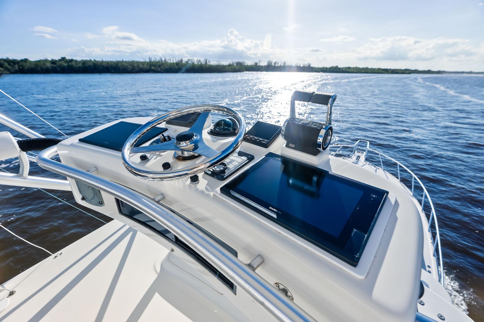 Helm of 2006 Cabo 45 Express yacht with modern navigation equipment on open water.