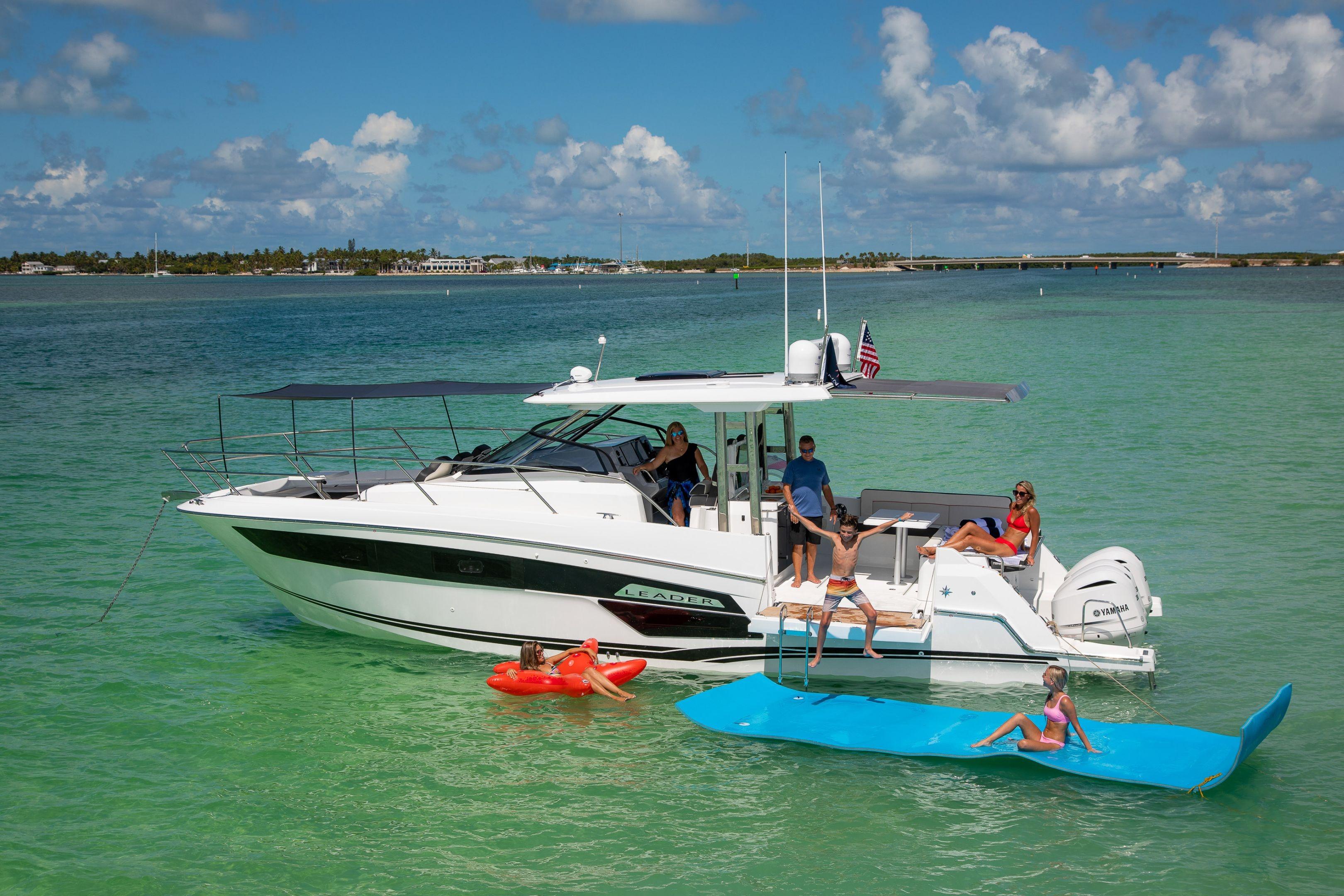 2026 Jeanneau Leader 12.5 WA yacht with people enjoying water activities.