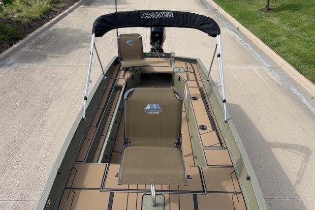 2026 Tracker Grizzly 1756 T Marsh boat with seating and canopy on a paved surface.