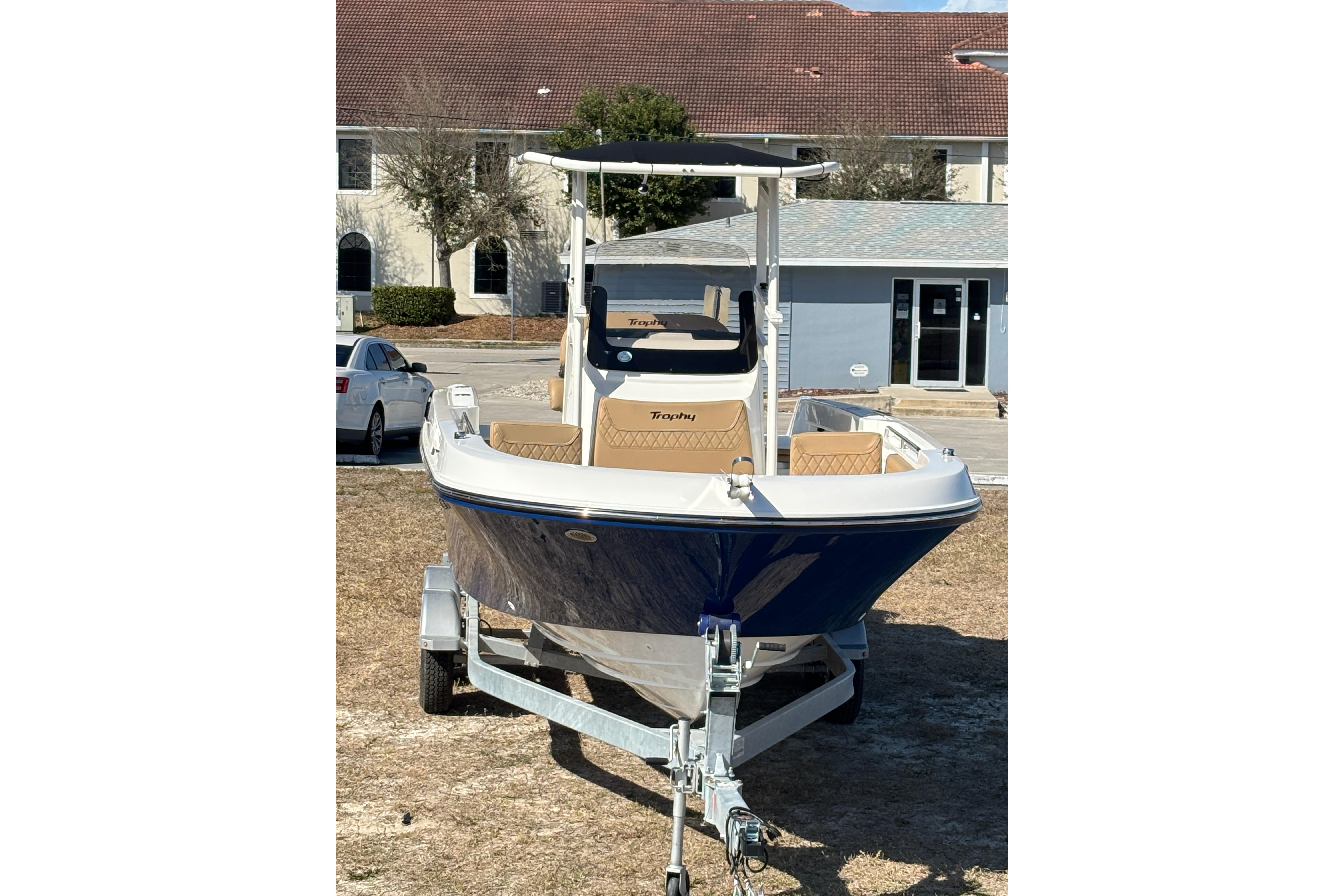 2026 Bayliner Trophy T22CC boat on trailer, parked outdoors.