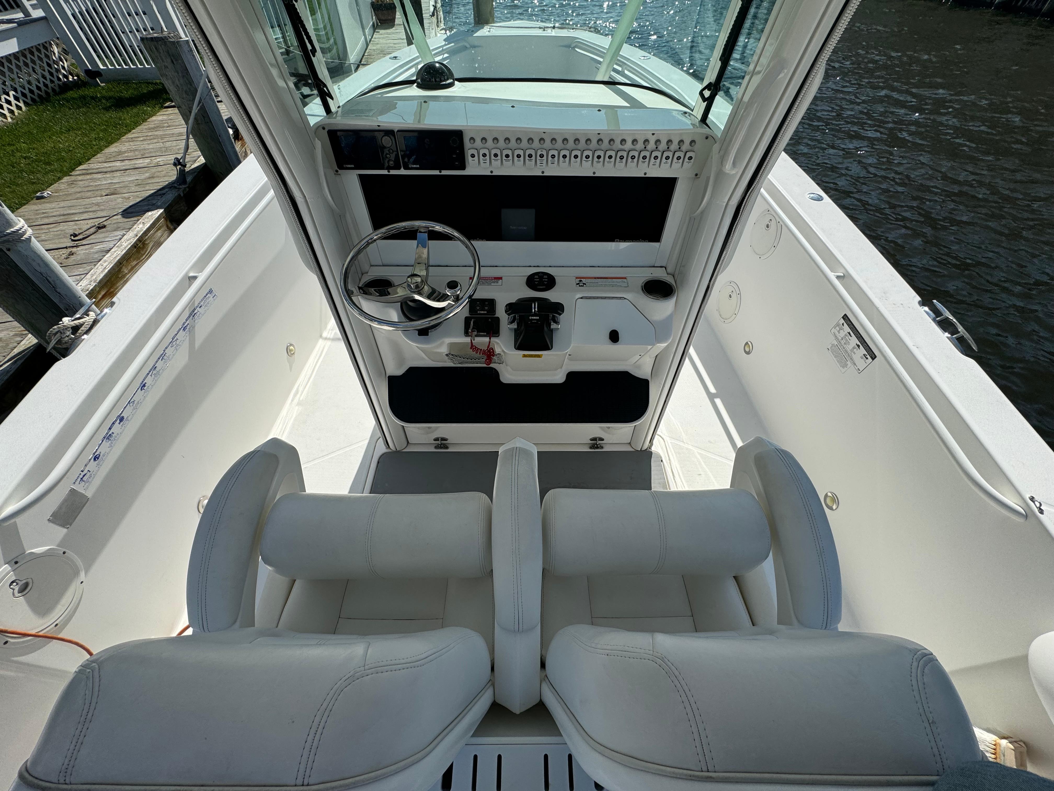 2011 Everglades 325 Center Console boat interior with dual seats and steering console.