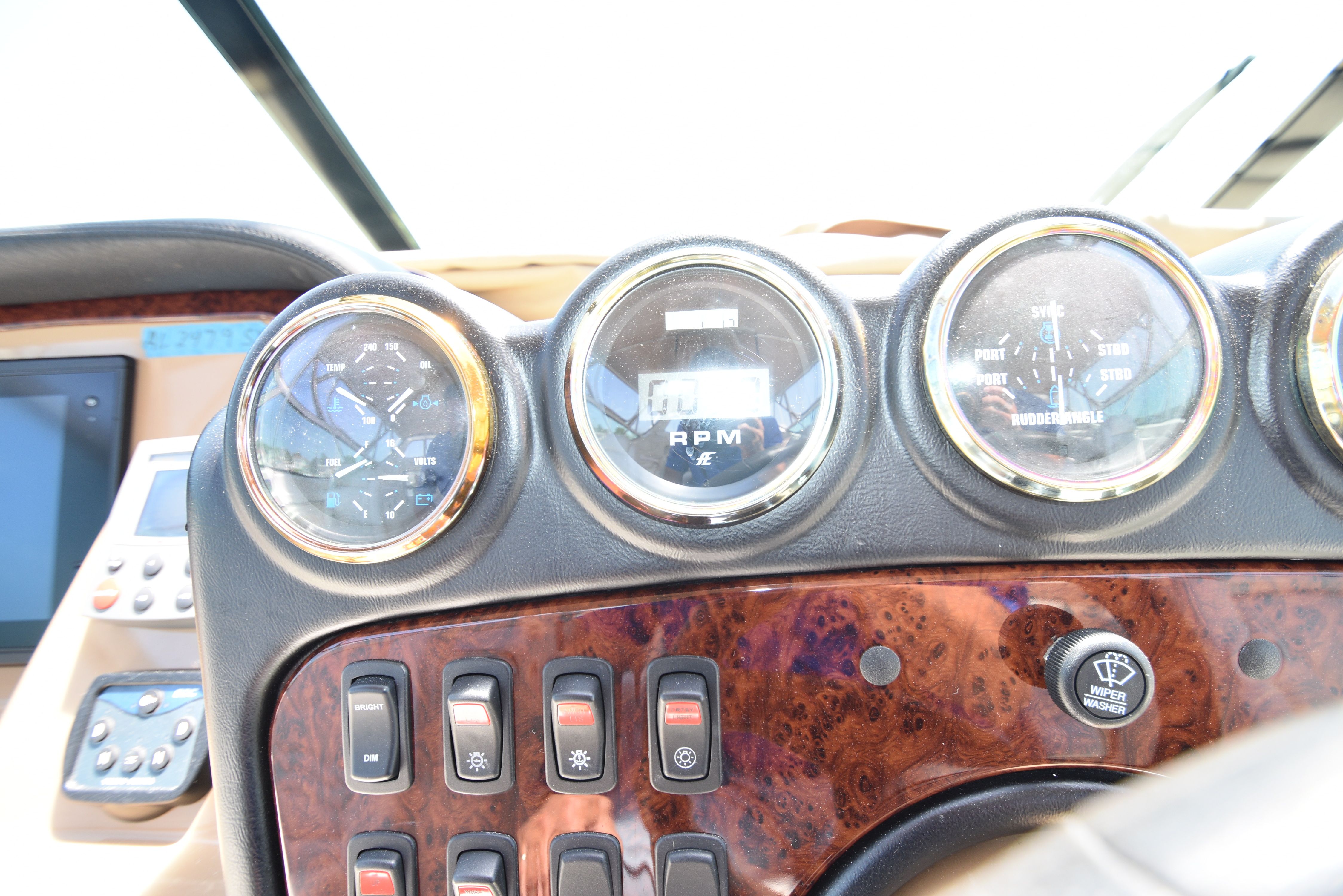 Close-up of a yacht dashboard with multiple gauges and switches.