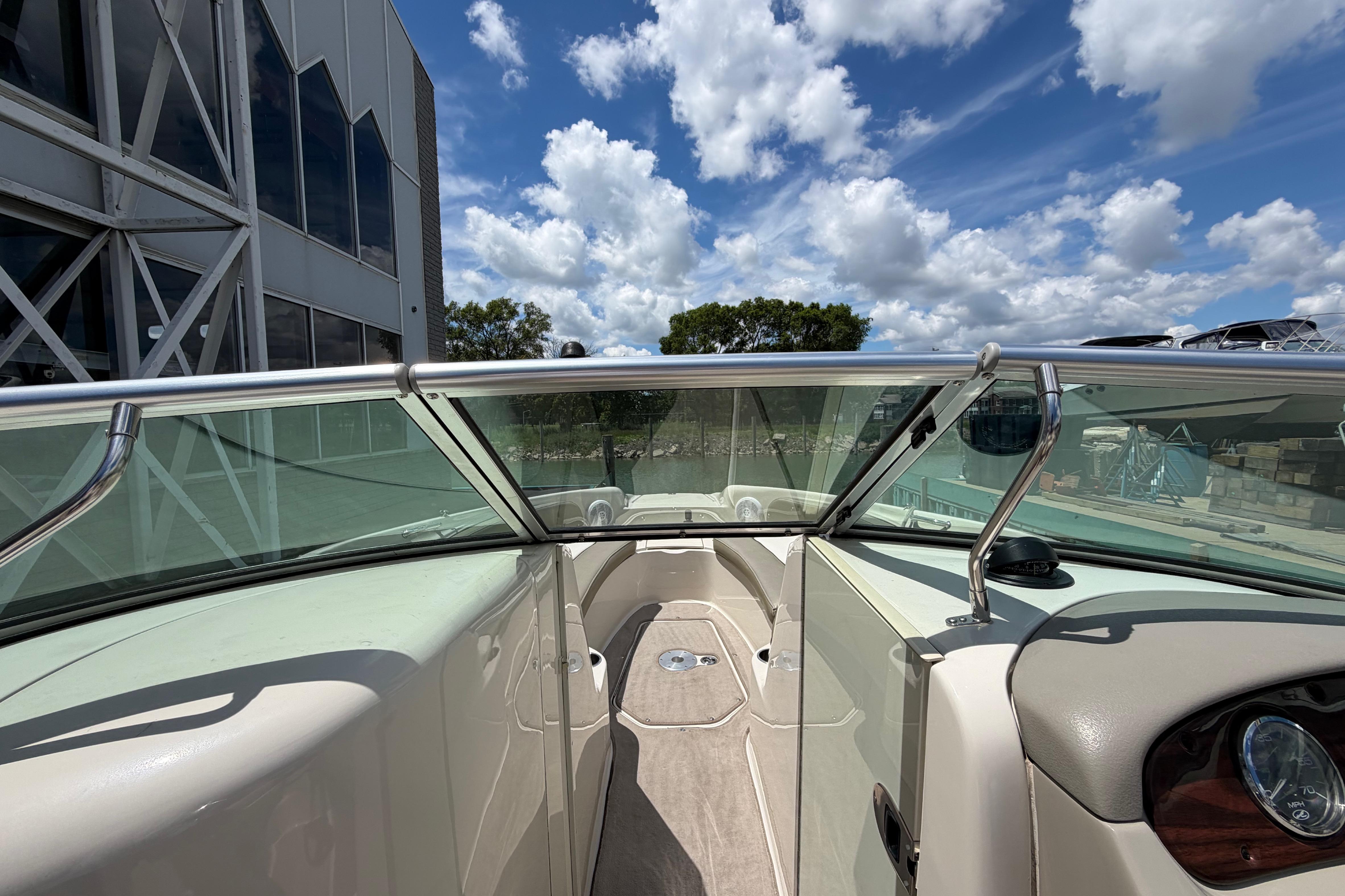 2004 Sea Ray 240 Sundeck boat interior with clear skies and modern architecture.