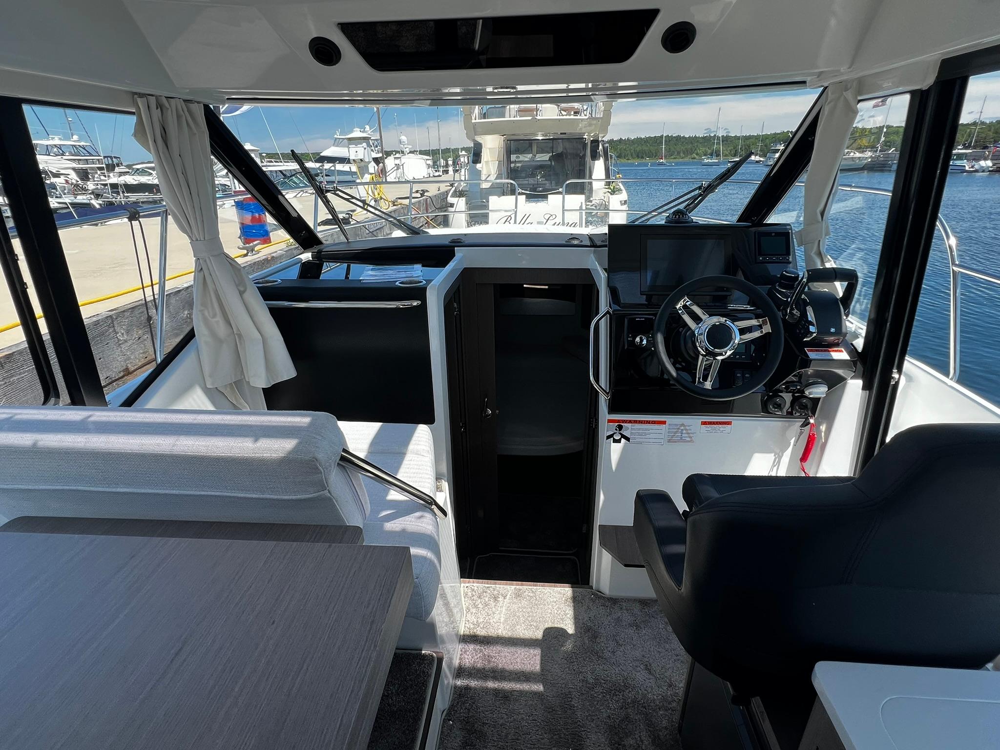 Interior view of 2025 Jeanneau NC 895 boat, featuring helm and seating area.
