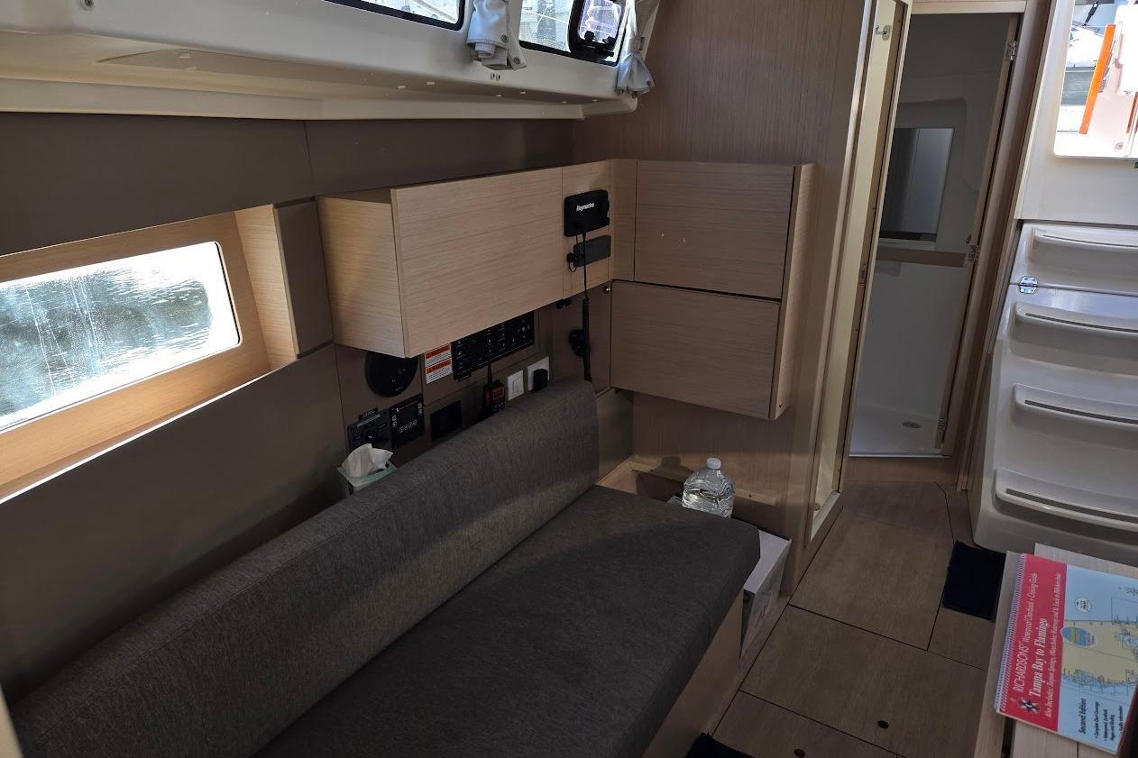 Interior of 2023 Beneteau Oceanis 38.1 yacht, featuring modern seating and cabinetry.