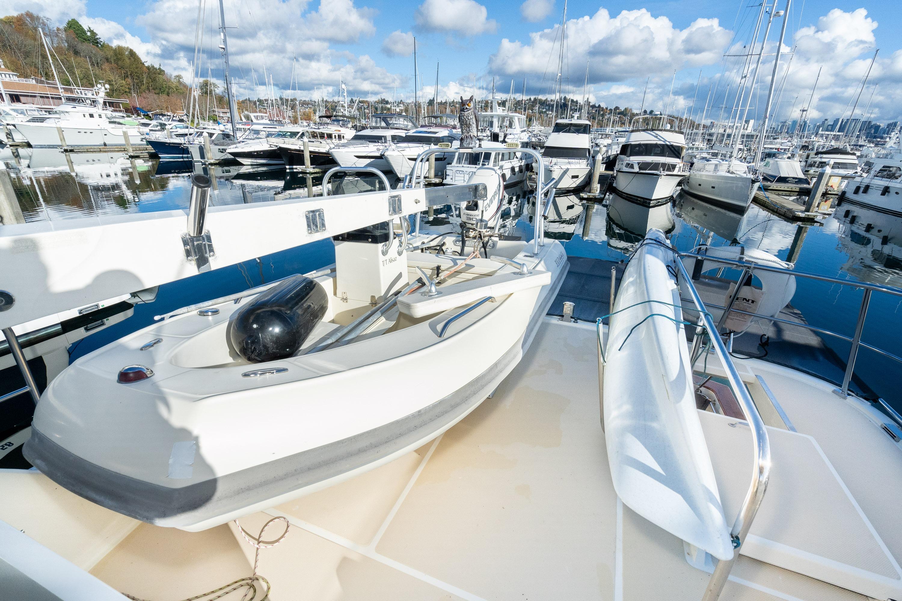 2001 Fleming 55 Pilothouse yacht docked at marina with clear skies and reflections.