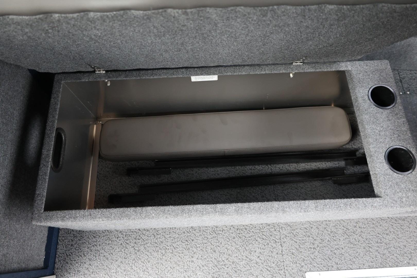 Storage compartment in 2026 Thunder Jet 24 Alexis Pro boat, featuring cup holders and carpeted interior.
