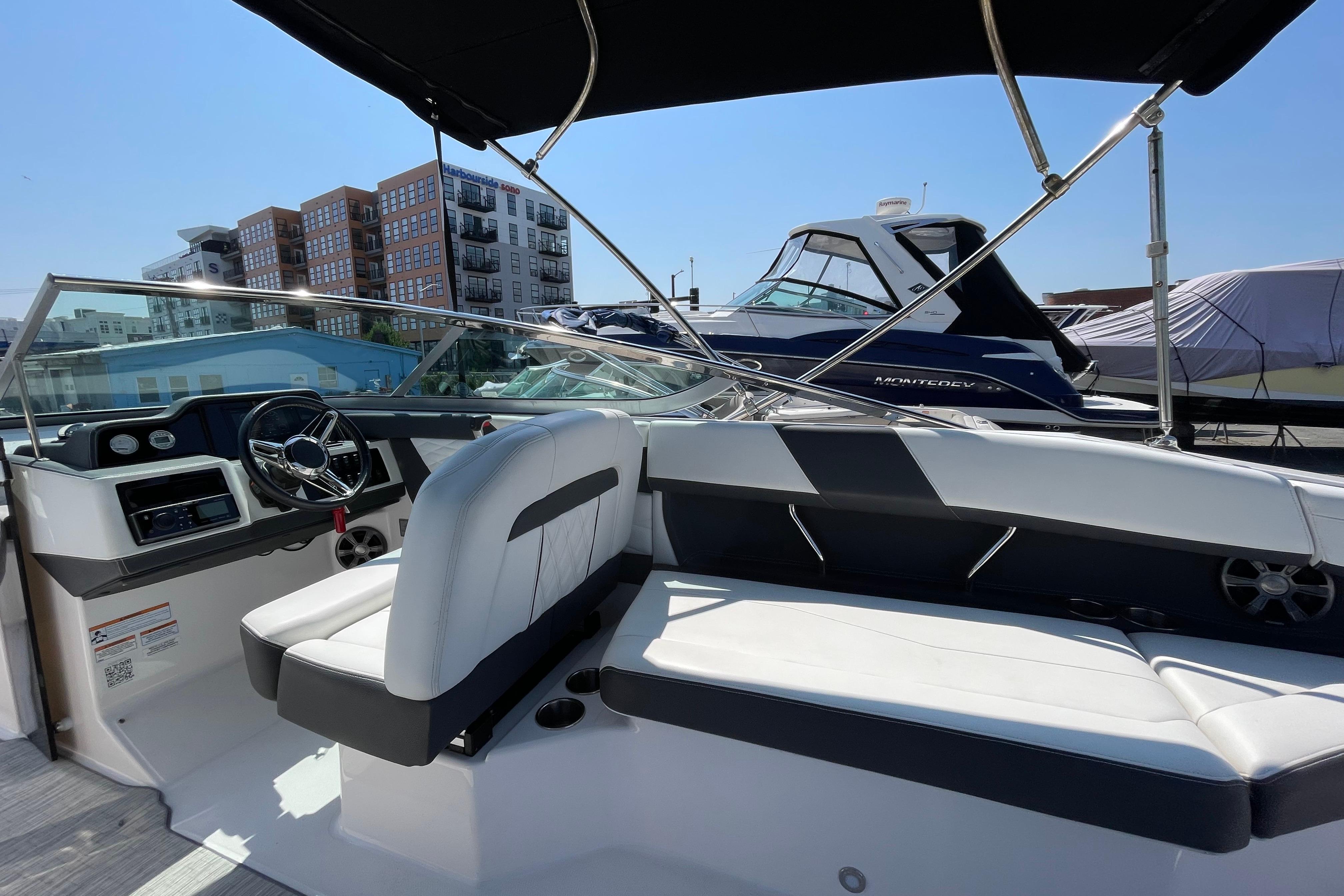 2018 Regal 26 OBX boat interior with modern seating and steering, docked near other boats.