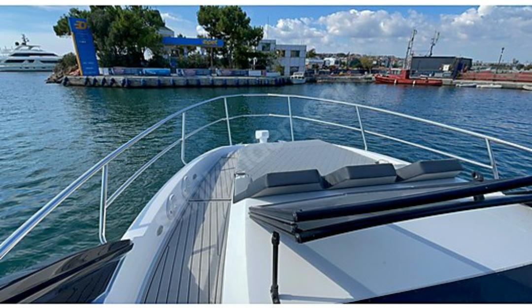 2021 NX Boats 340 Sport Coupe on water near marina, sunny day.