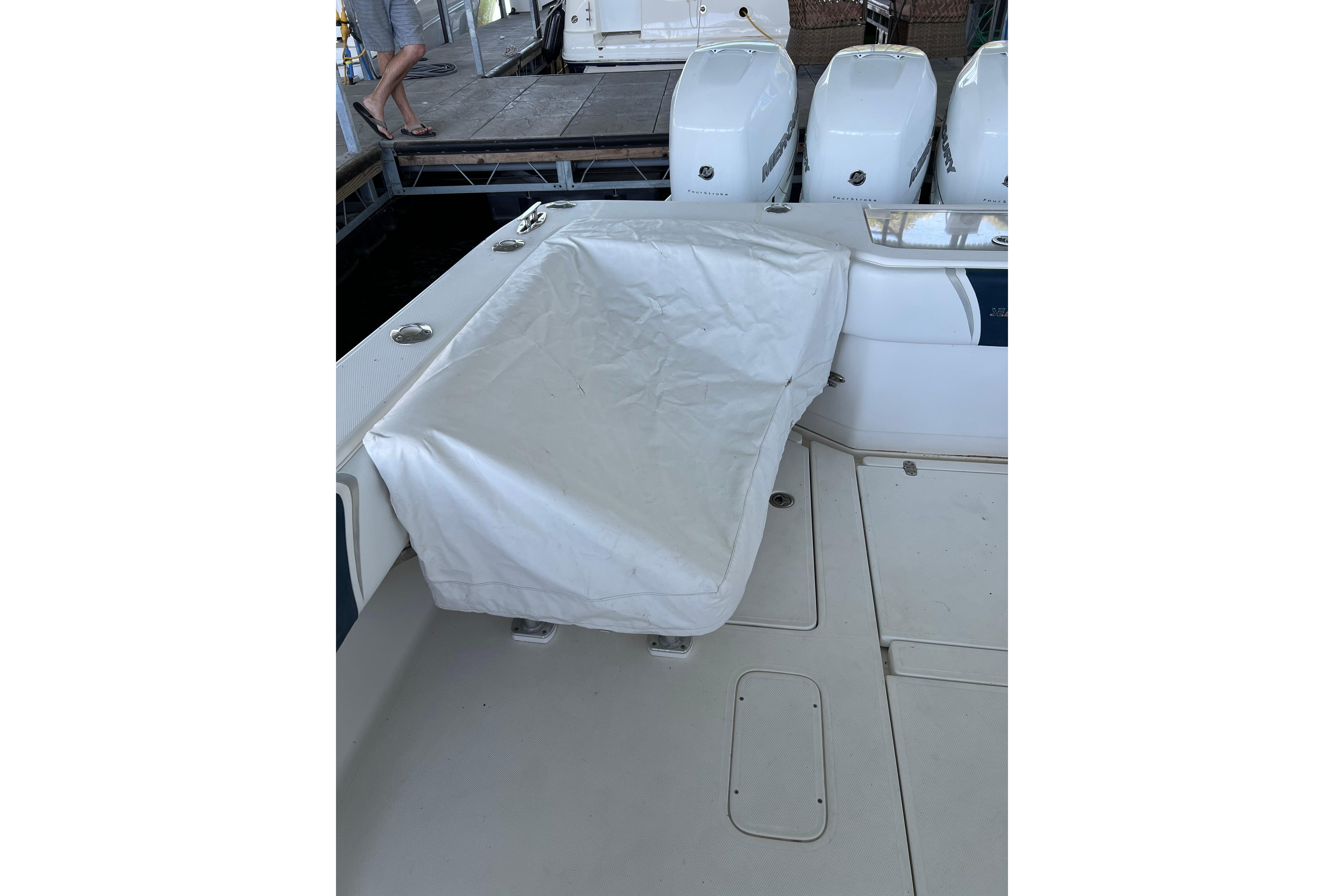 2008 SeaVee 39 boat with covered seating and multiple outboard engines at dock.