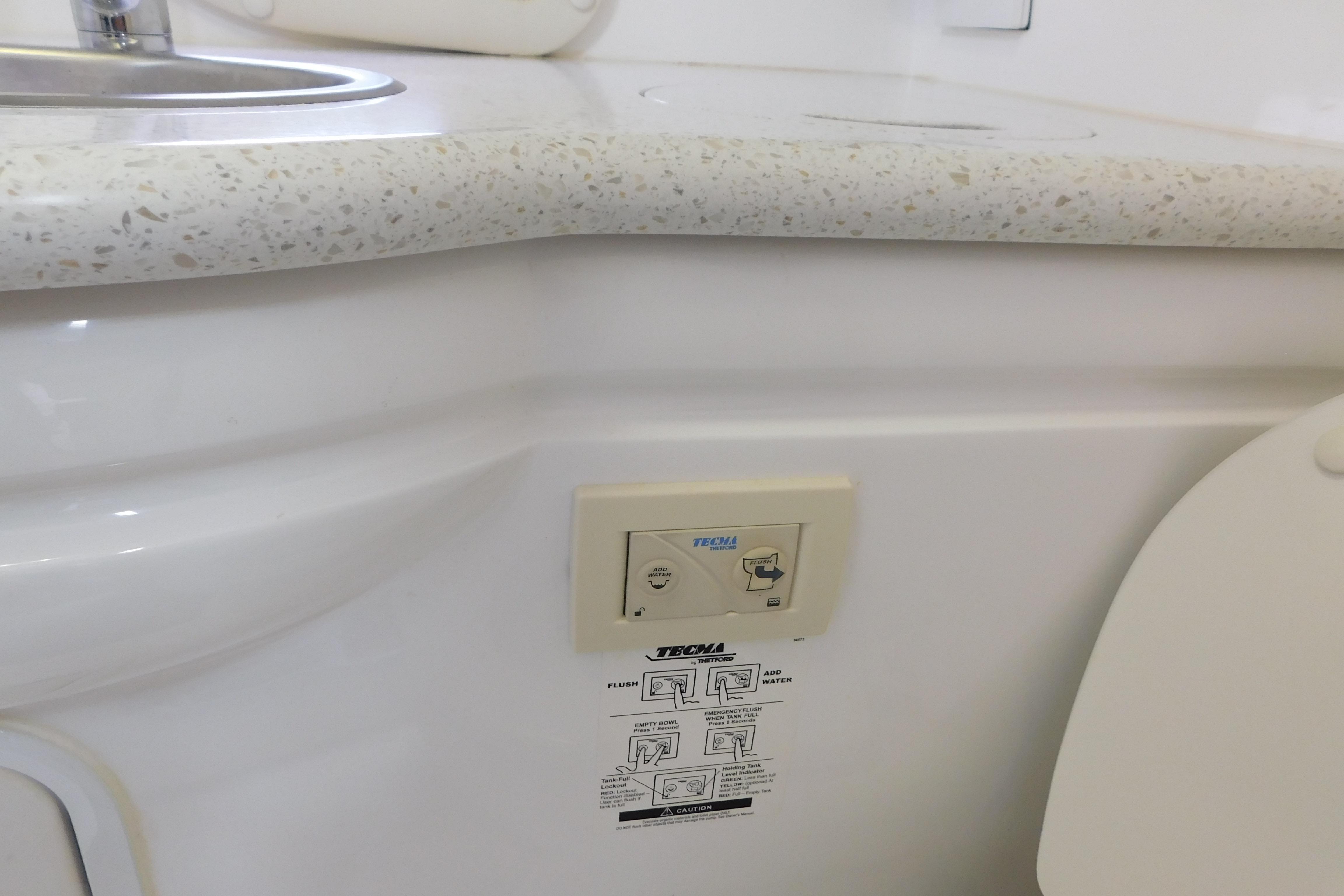 2017 Rinker EX 320 boat bathroom with sink and Tecma toilet control panel.