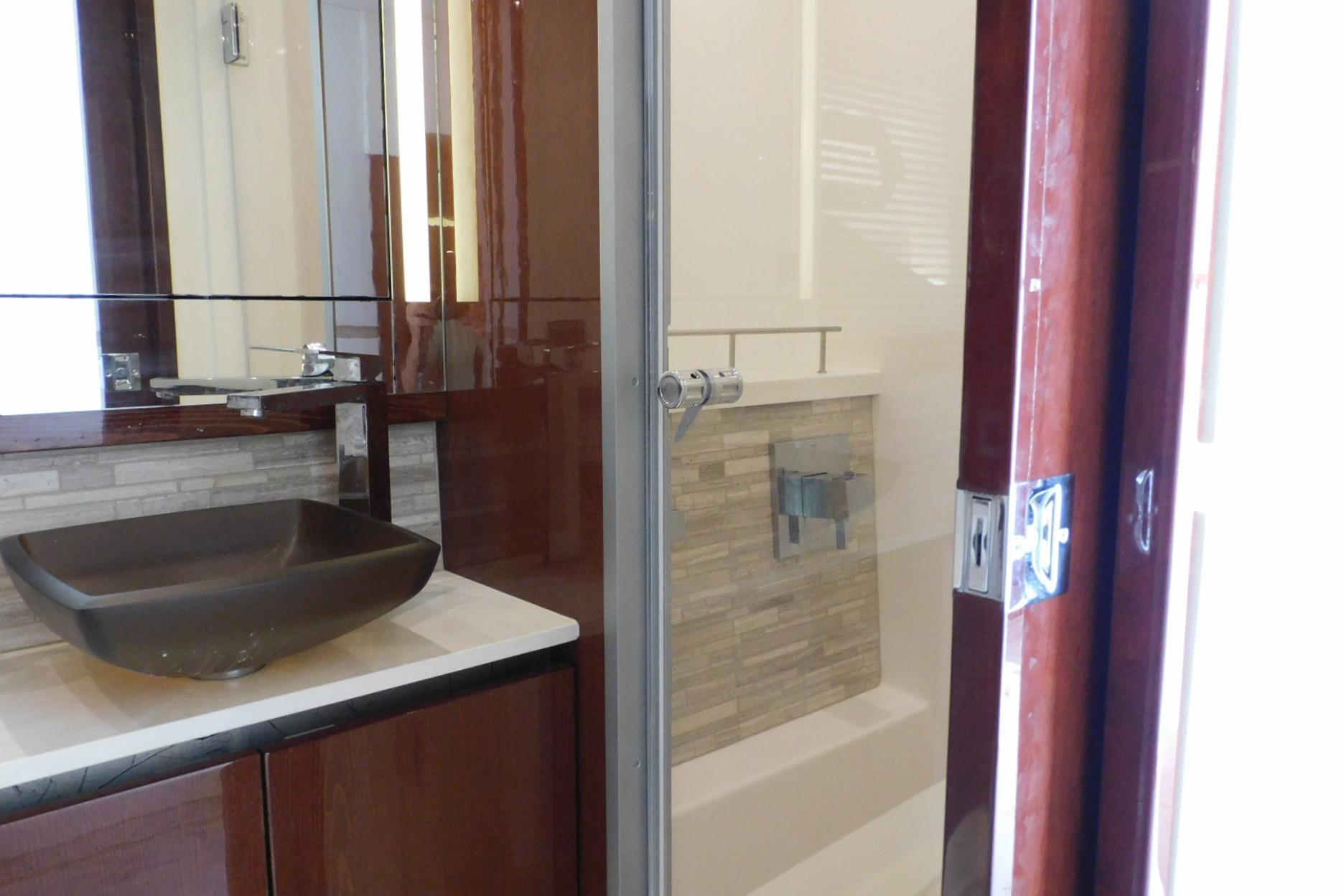 Luxurious bathroom interior of 2019 Sea Ray L550 yacht with modern sink and shower.