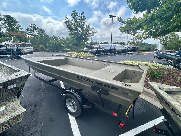 2025 Tracker GRIZZLY 1860 Utility boat on trailer in parking lot.