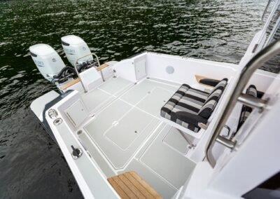 2024 True North 34 boat deck with twin engines and seating on water.
