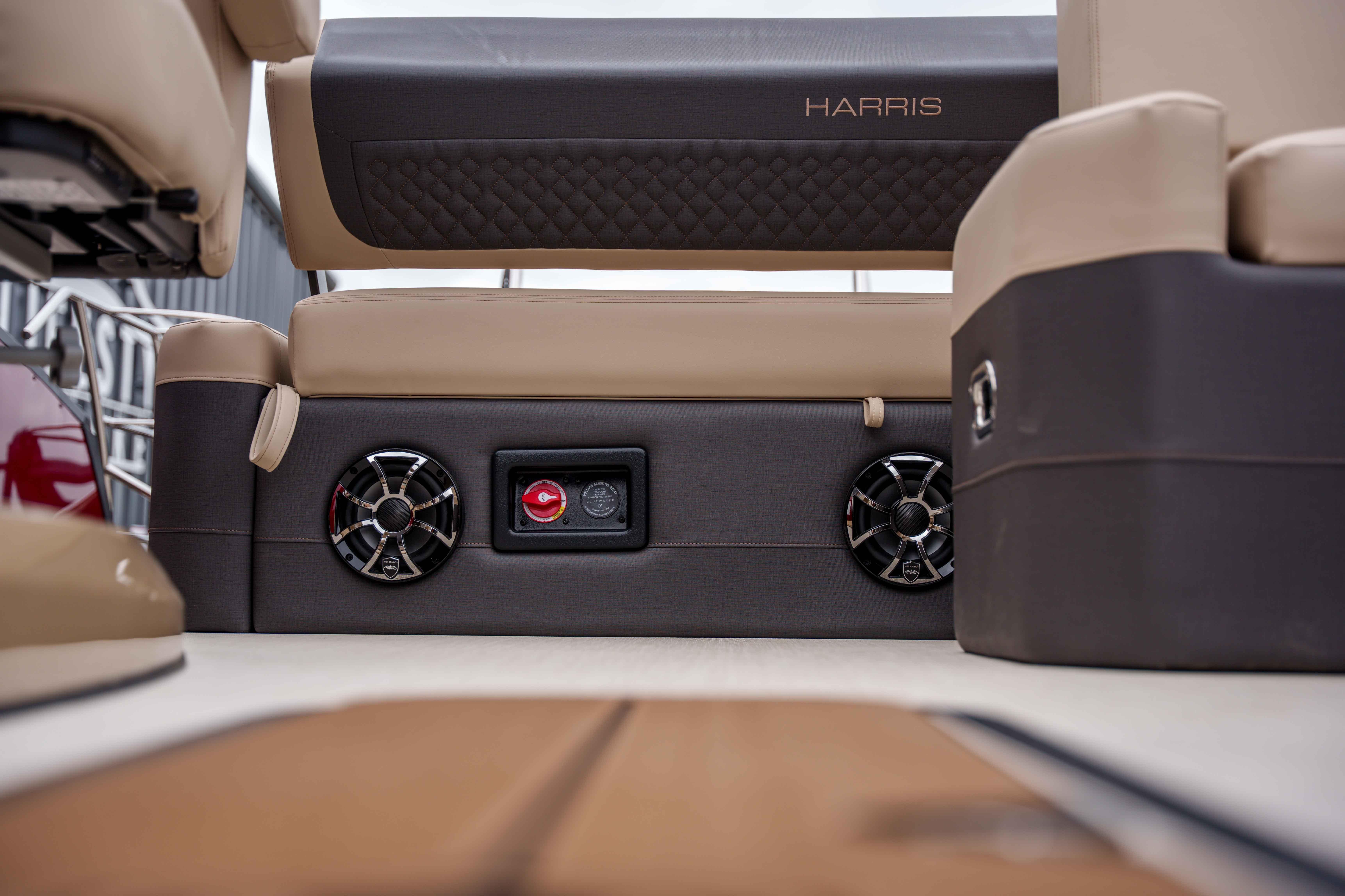 Interior of 2026 Harris Sunliner 230 boat featuring speakers and luxurious seating.