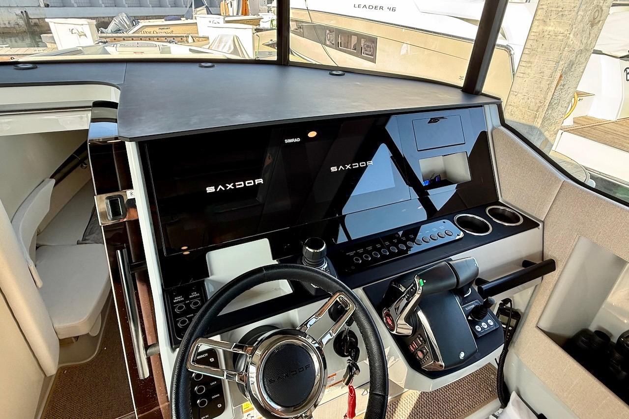 2024 Saxdor 320 GTC boat cockpit with modern steering and control panel.