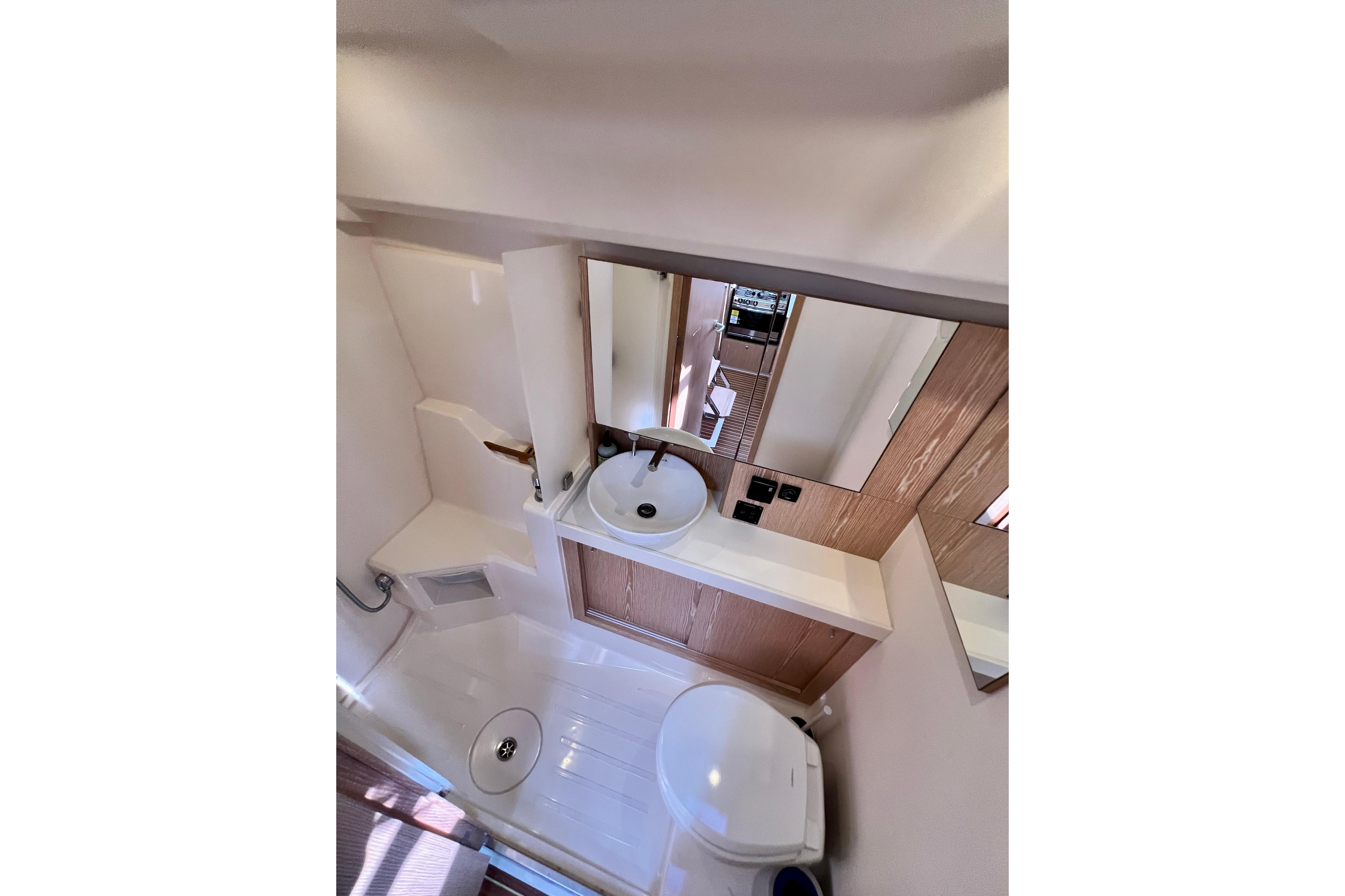Bathroom interior of 2016 Hanse 455 yacht, featuring sink, mirror, and toilet.