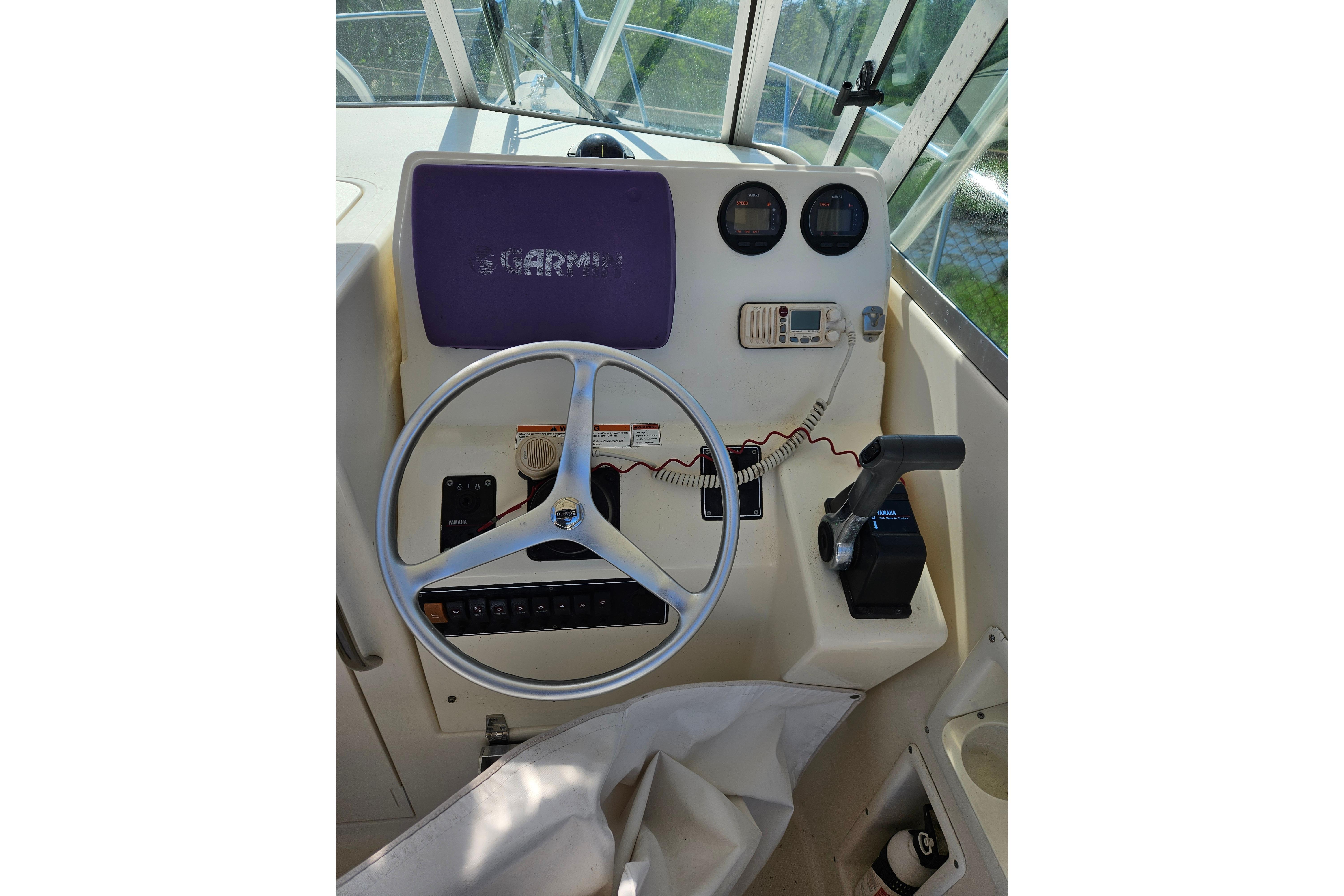 2004 Pursuit 2470 Walkaround boat helm with steering wheel and control panel.