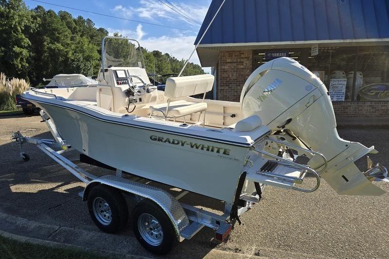 2026 Grady-White Fisherman 180 boat on trailer, parked outside a building.