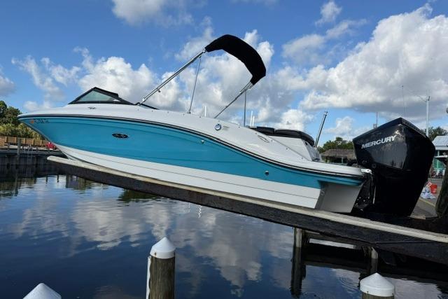 2022 Sea Ray SPX 210 Outboard boat on lift, blue and white design, docked by water.