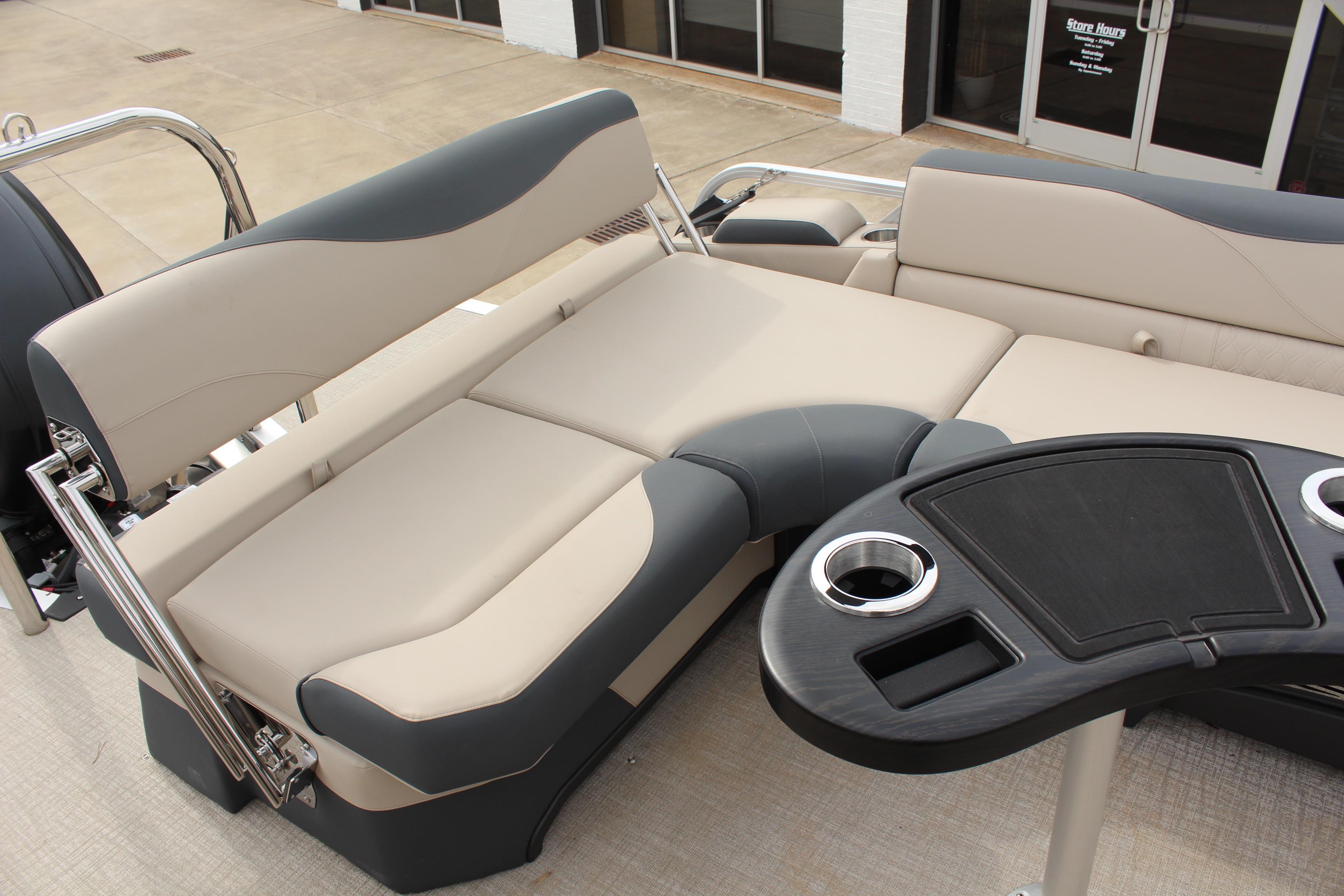 2026 Tahoe Pontoon LTZ interior with beige and gray seating, featuring a sleek black table.