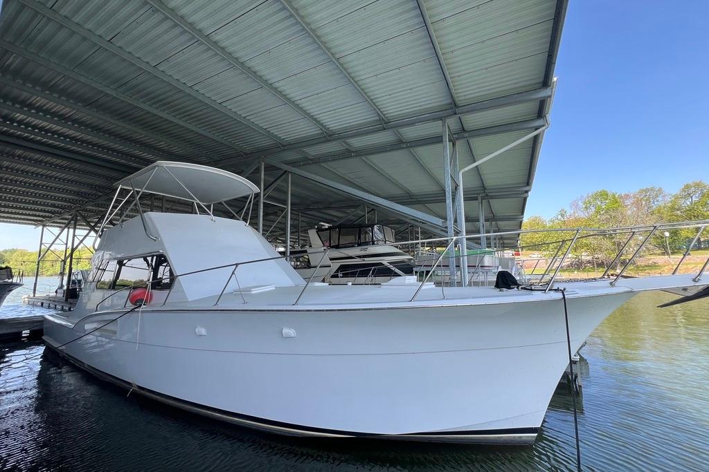 1976 Hatteras 53 Convertible yacht docked under a covered marina.