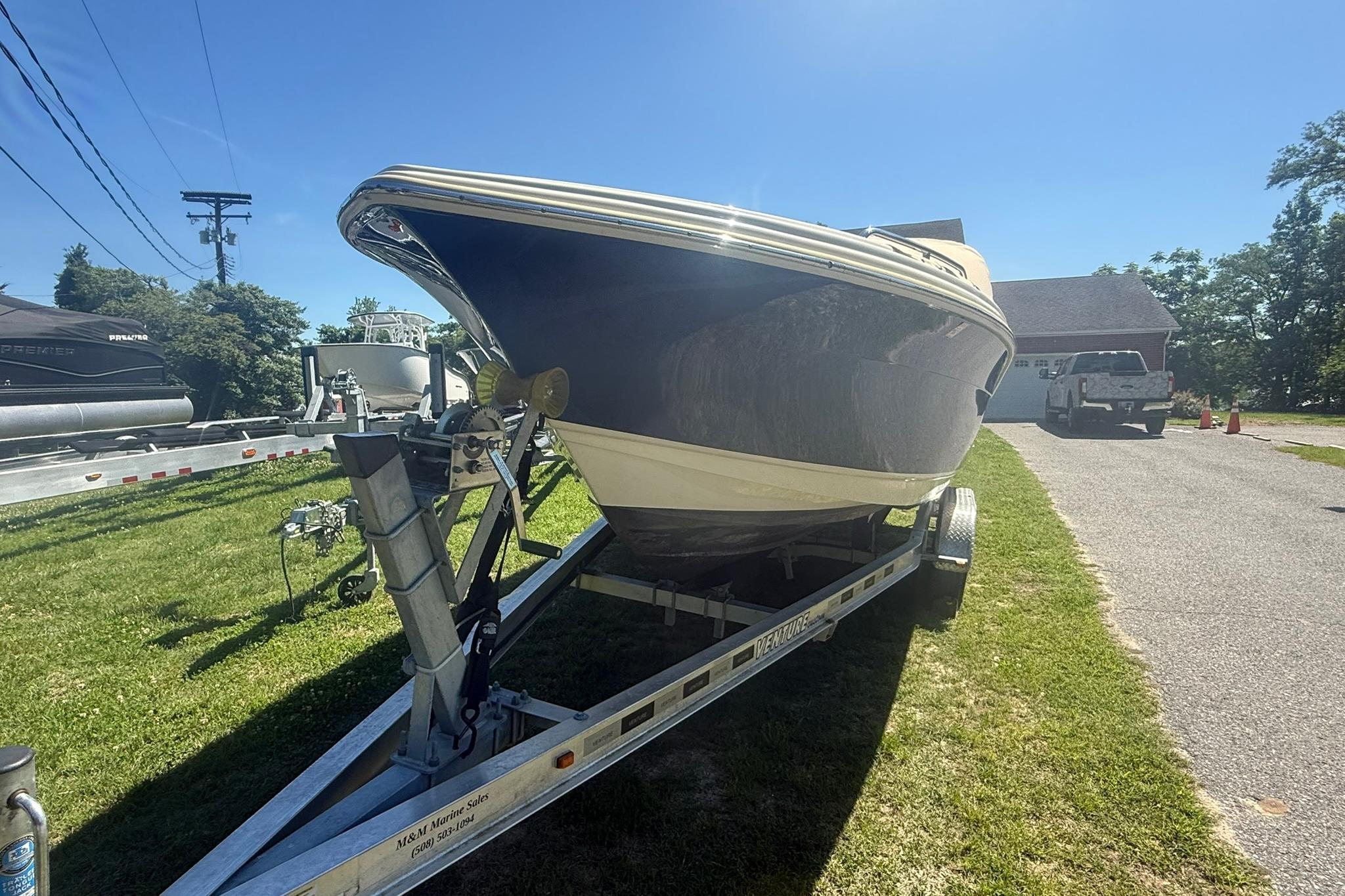 2021 Scout 215 Dorado boat on trailer in driveway, sunny day.
