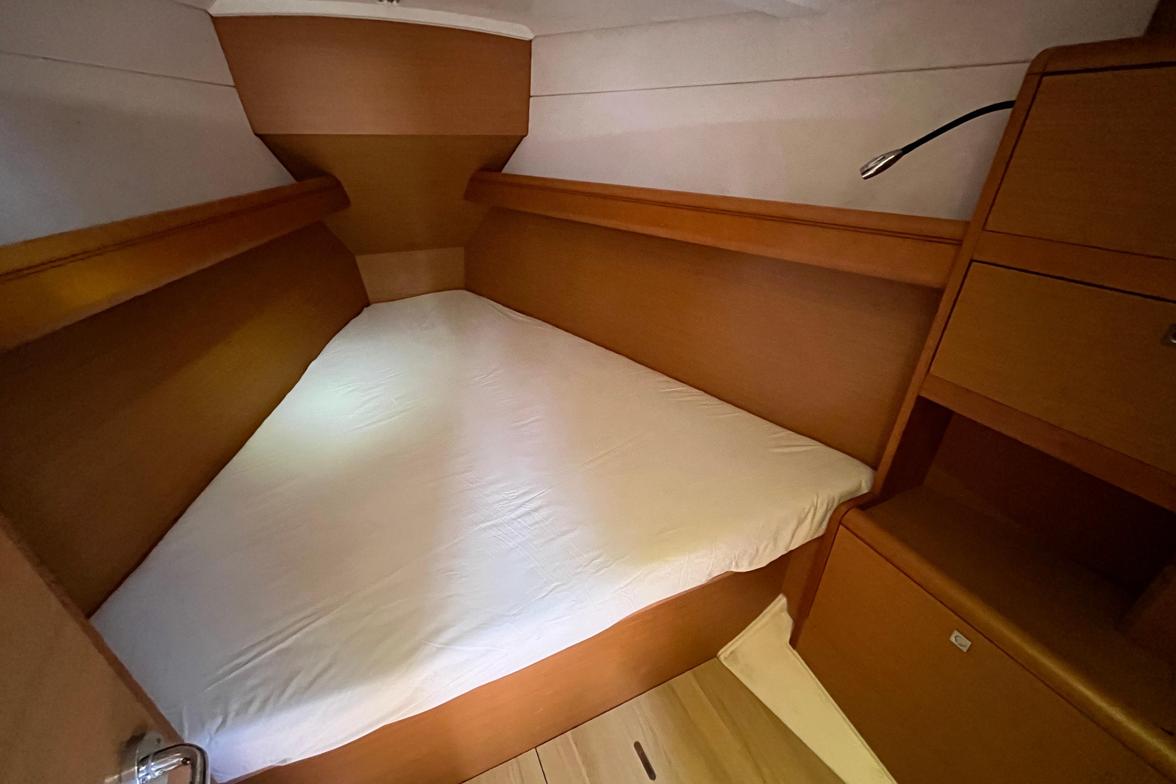 Cozy cabin interior of 2013 Jeanneau Sun Odyssey 379 sailboat with wooden finish.