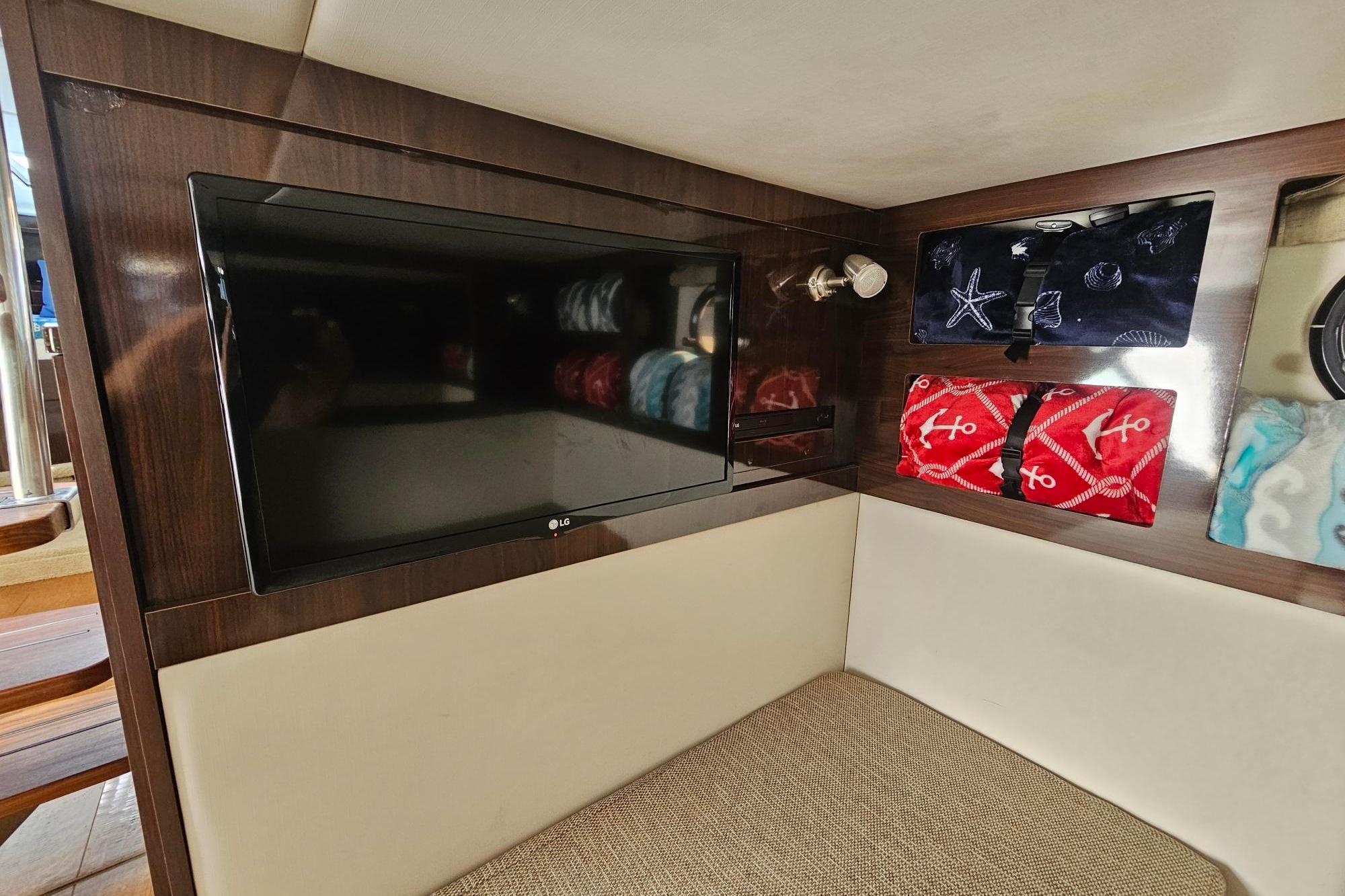Interior of 2016 Sea Ray Sundancer 350 with TV and decorative storage shelves.