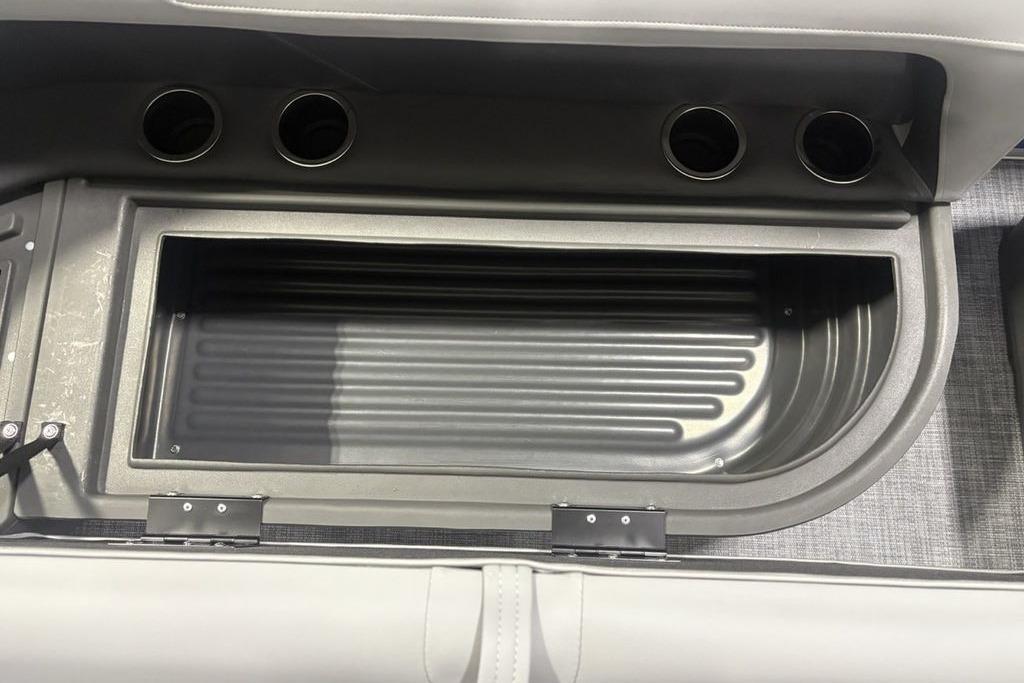 Interior storage compartment of 2026 Sun Tracker Party Barge 16 DLX with cup holders.