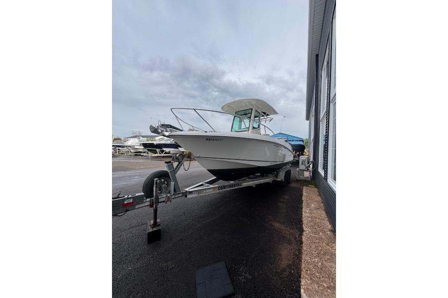 2015 Boston Whaler 250 Outrage boat on trailer, parked outdoors.