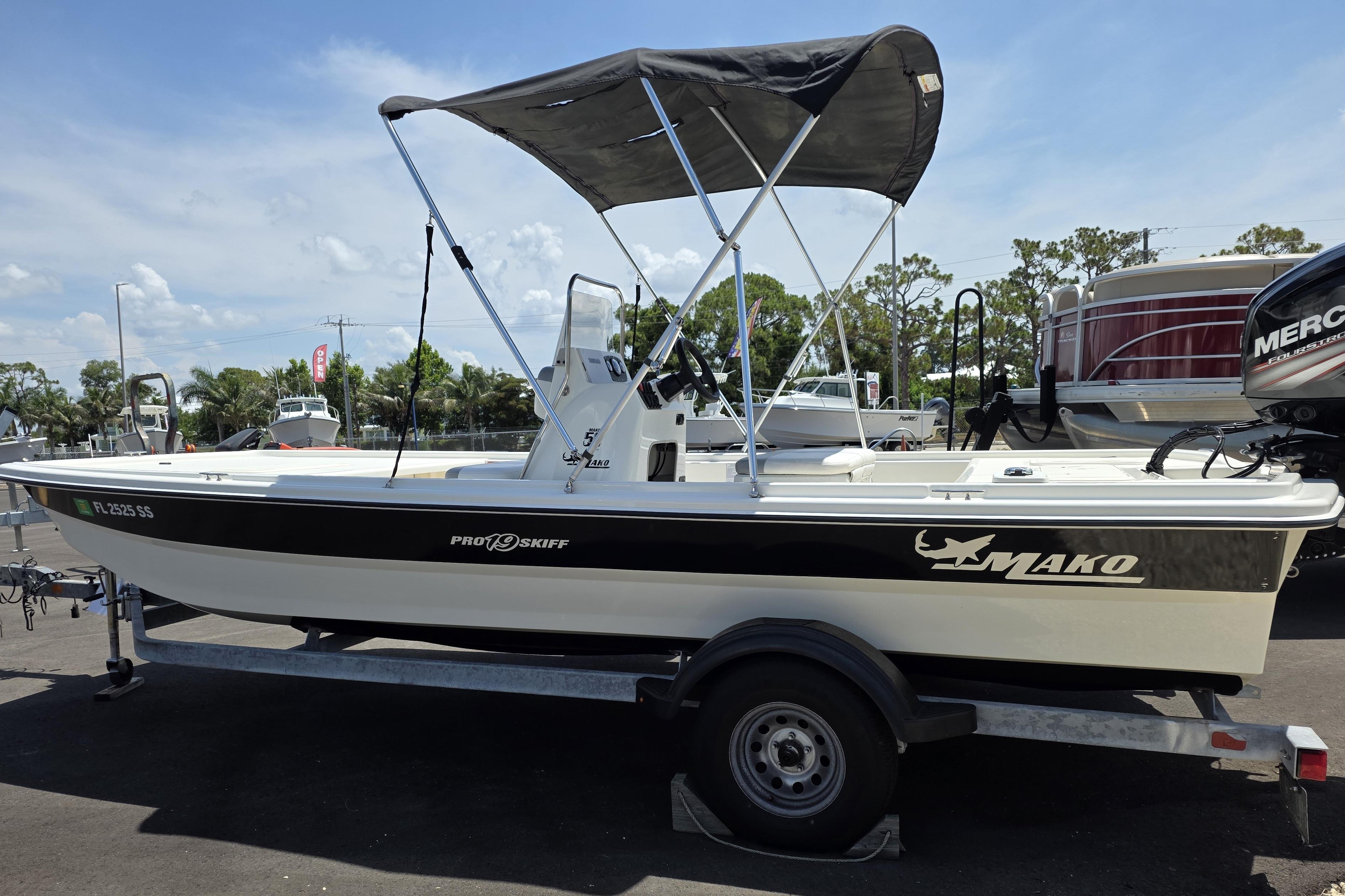 2018 Mako Pro Skiff 19 CC boat on trailer with canopy, parked outdoors.
