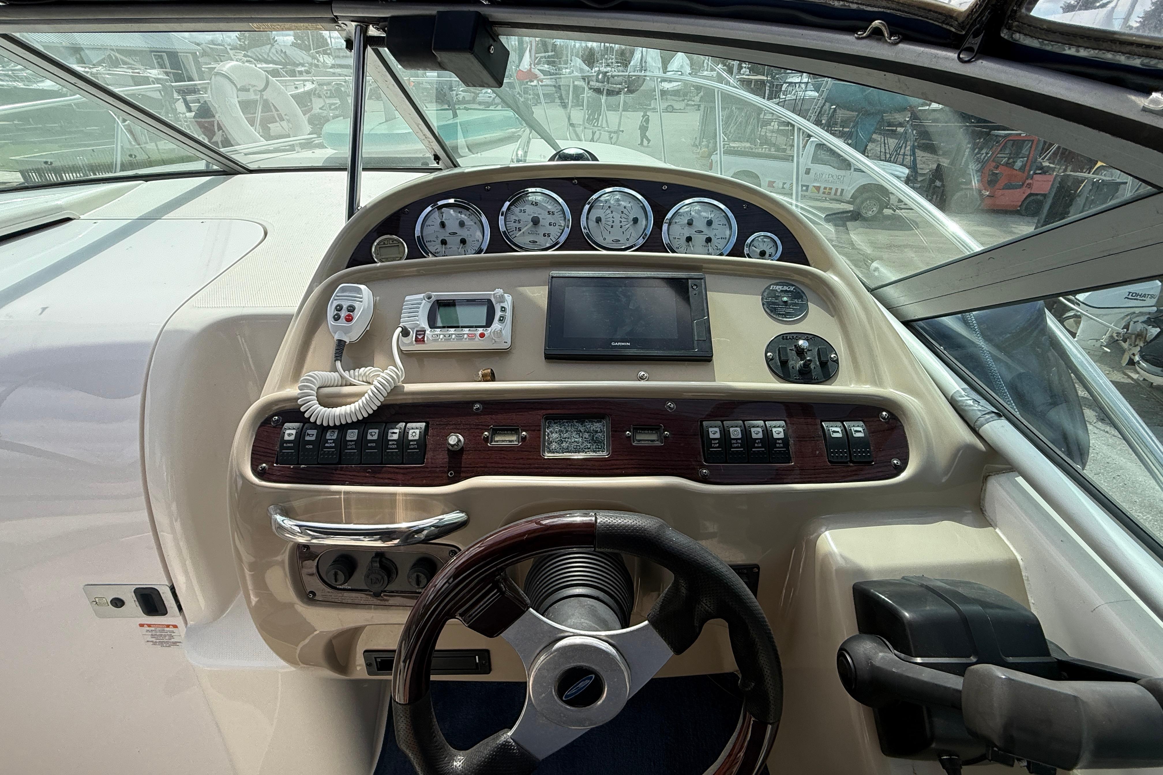 Cockpit of 2003 Chaparral Signature 280 boat with steering wheel and control panel.