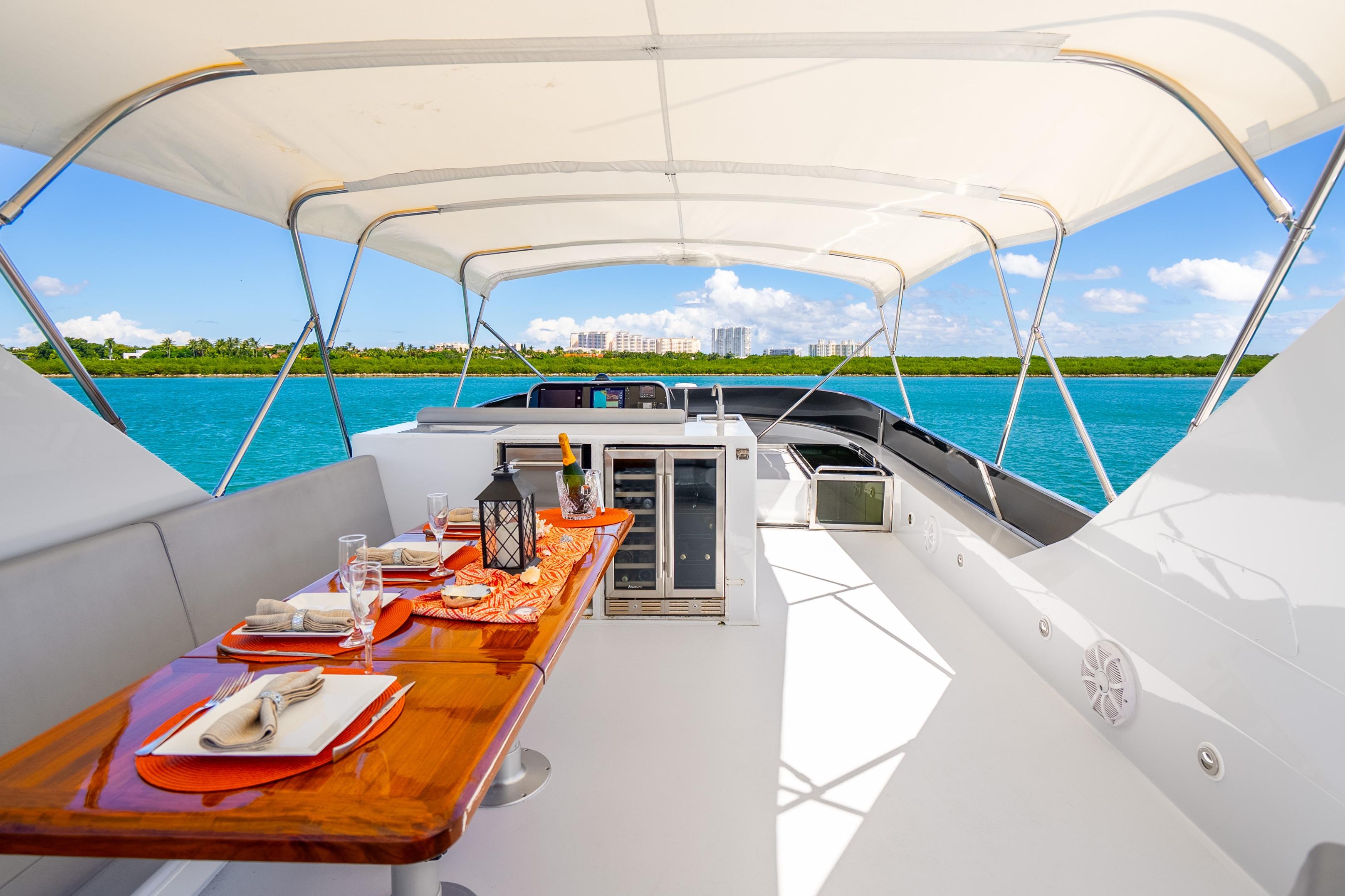 Luxurious 1991 Maiora Planning yacht deck with elegant dining setup, overlooking serene blue waters.