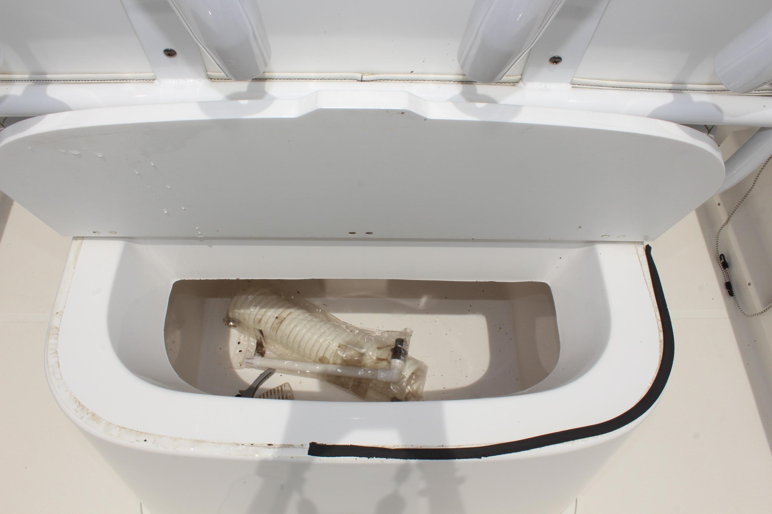2024 Clear Water 2200 CC boat storage compartment with hose inside.