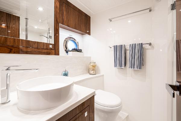 Luxurious bathroom in 2021 Riviera 5400 Sport Yacht with modern fixtures and elegant design.