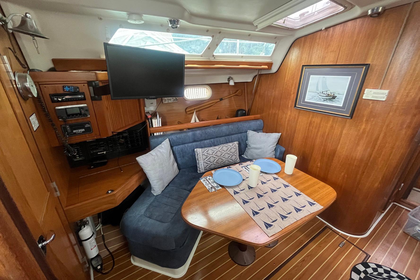 Interior of 2003 Catalina 350 sailboat with cozy dining area and nautical decor.