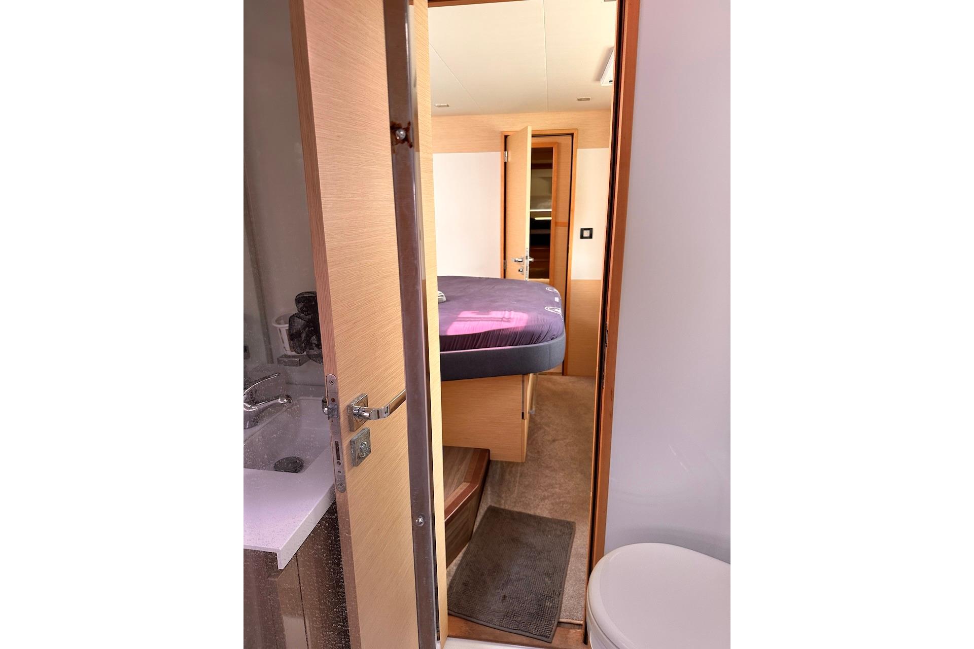 Interior cabin view of 2016 Fountaine Pajot Ipanema 58 yacht, featuring a cozy bedroom and bathroom.