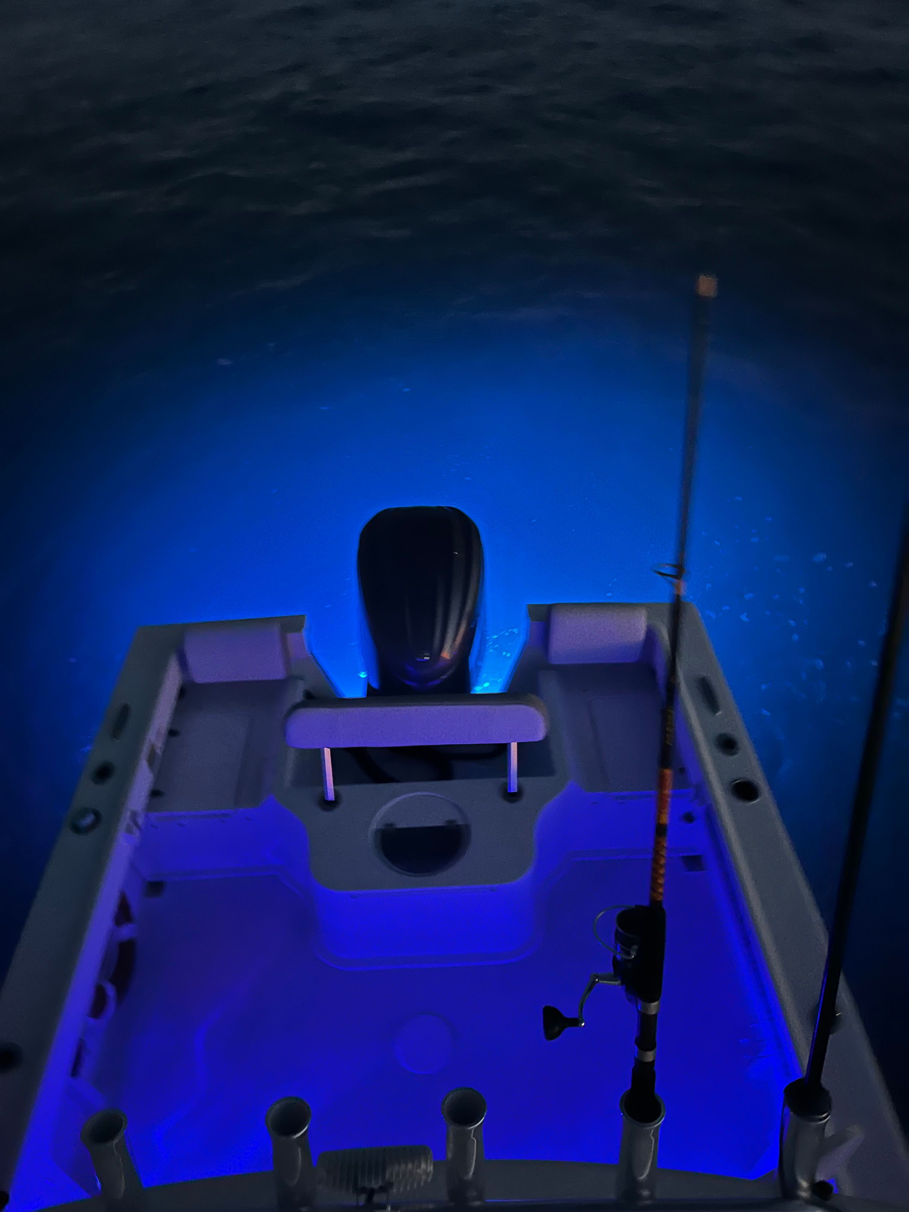 The image shows the stern of a Parker 2021 sport cabin boat with blue underwater lighting.