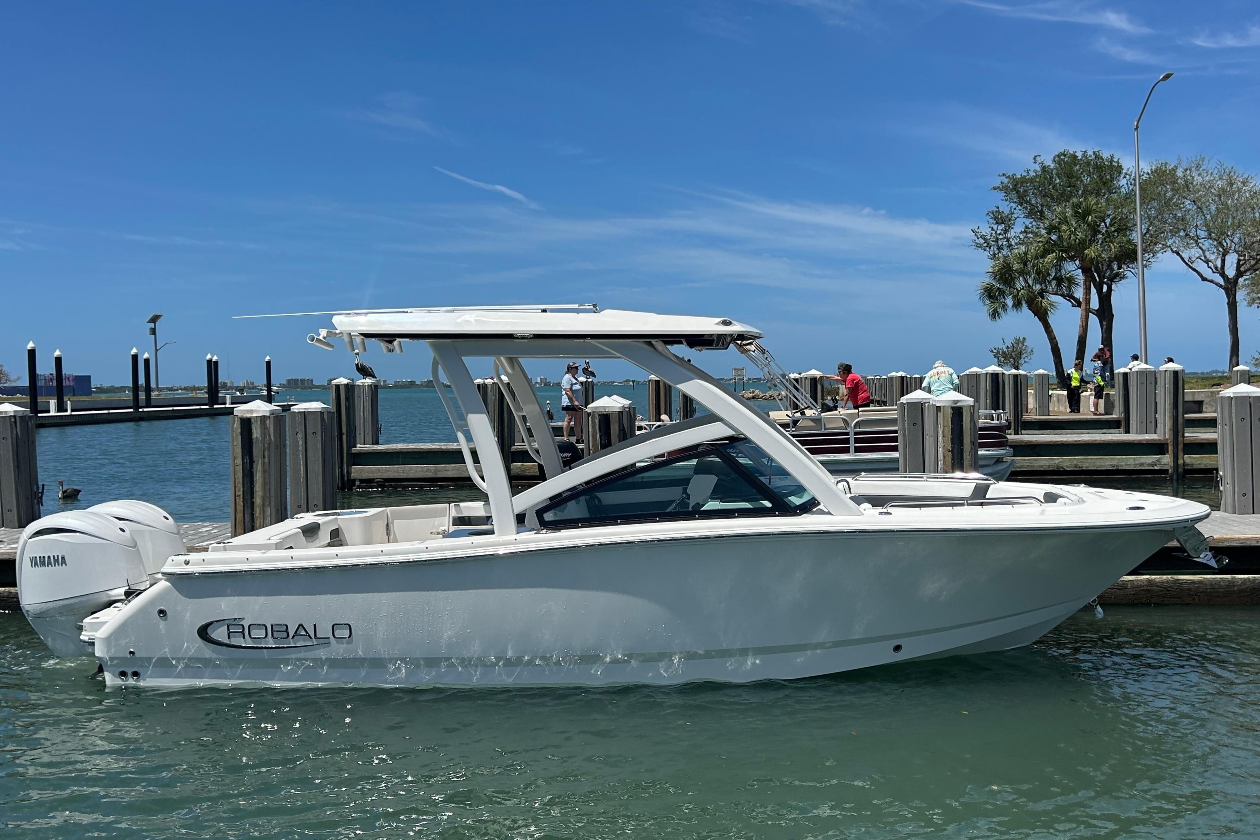 2026 Robalo R257 Dual Console boat docked in sunny marina with Yamaha engine.