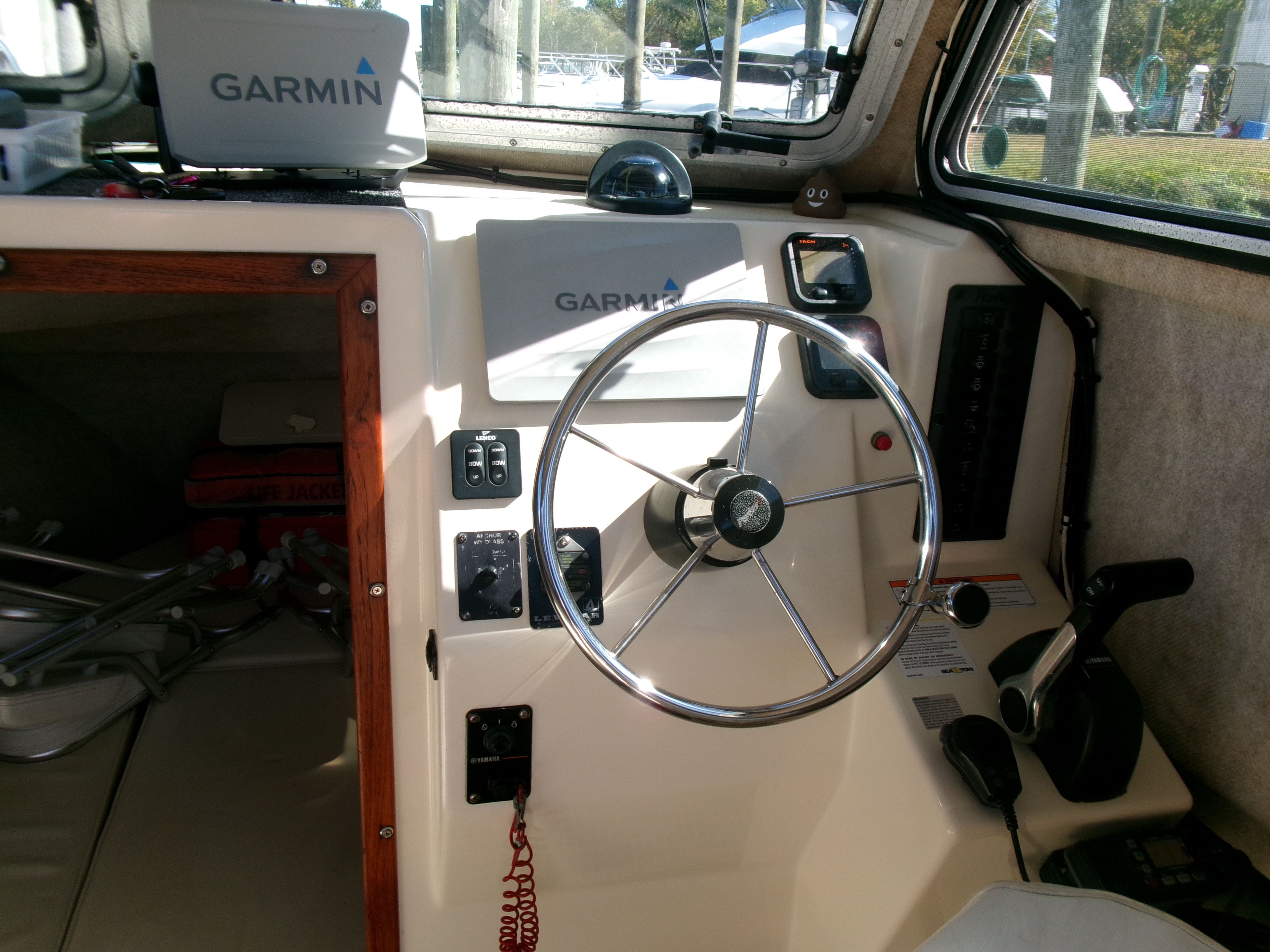 Interior view of the Parker 2520 XL Sport Cabin with steering wheel, Garmin devices, and beige interior.