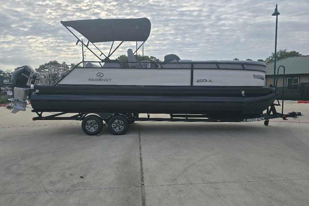 2025 Regency 250 LE3 Sport pontoon boat on trailer, parked outdoors.